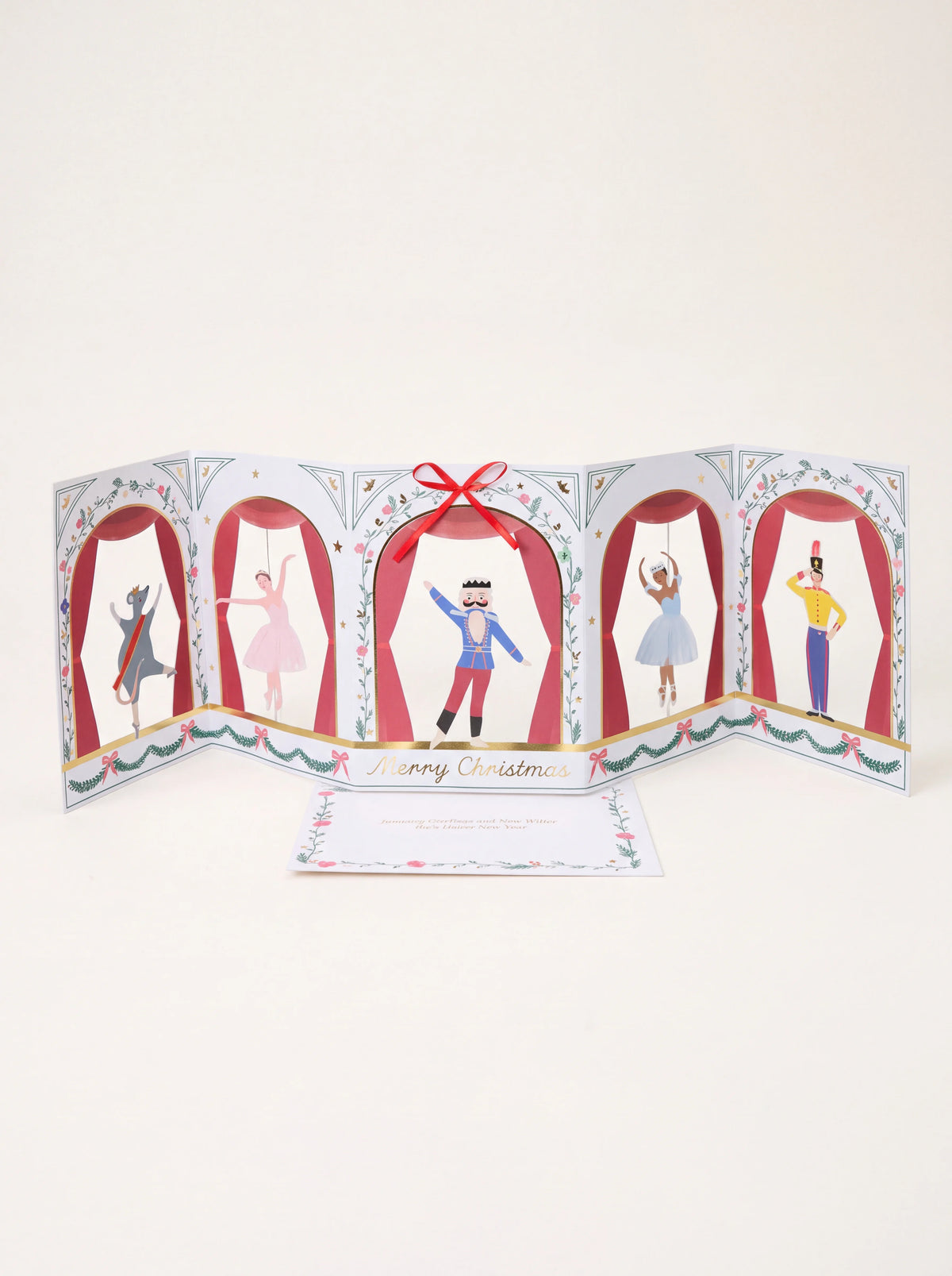 Nutcracker concertina card with five illustrated stage panels, red ribbon bow and printed greeting insert