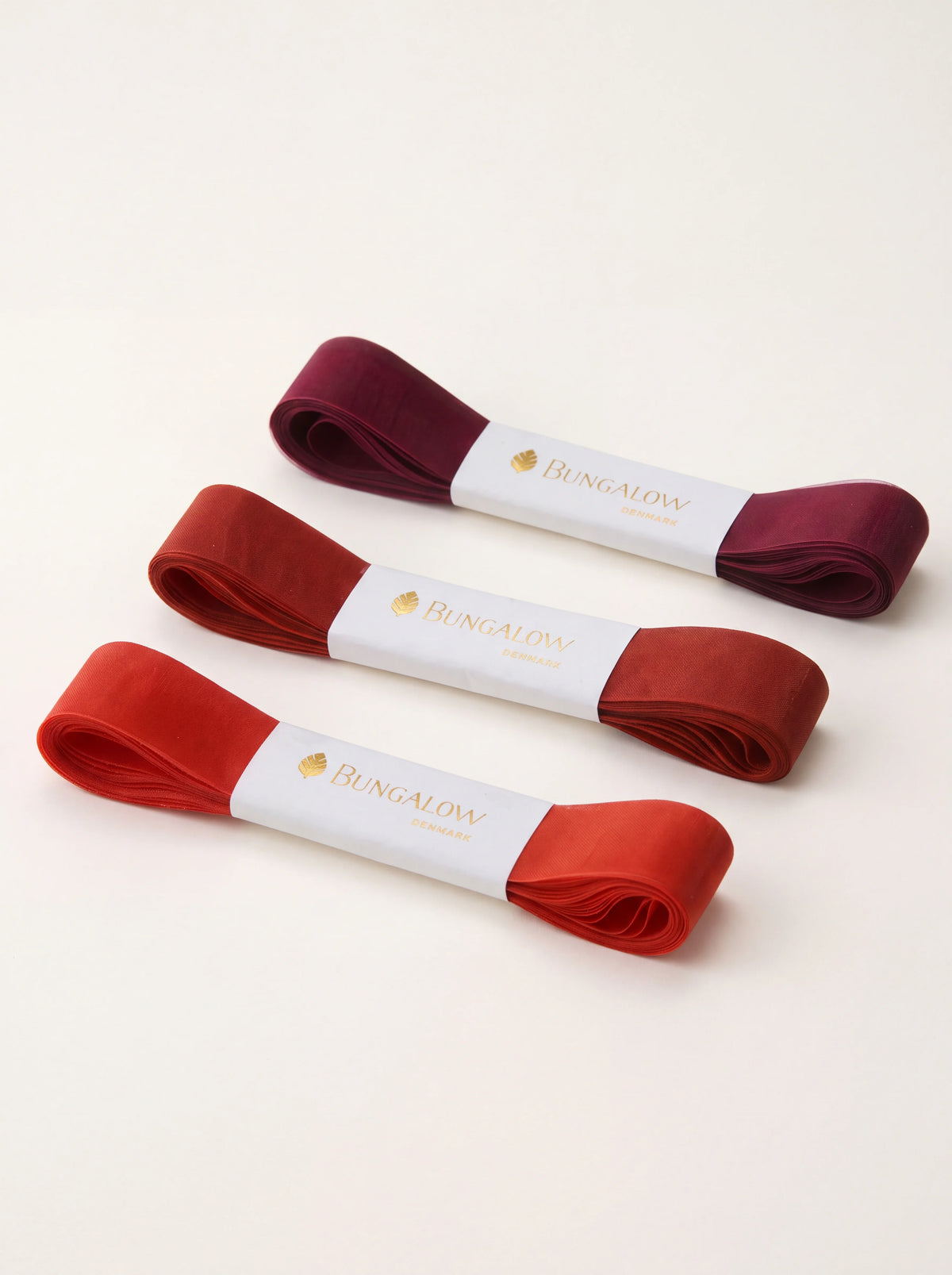 Set of three sheer polyester organza ribbons in graduated shades of cherry red and deep burgundy