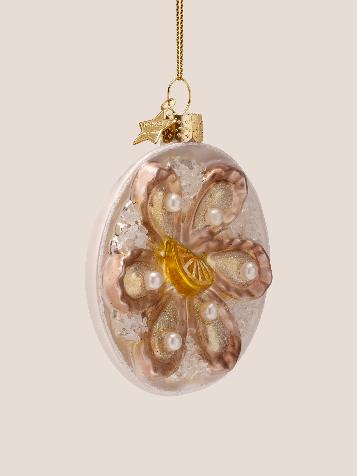 Three-quarter view of the oyster plate ornament showing the raised relief of the shells and lemon