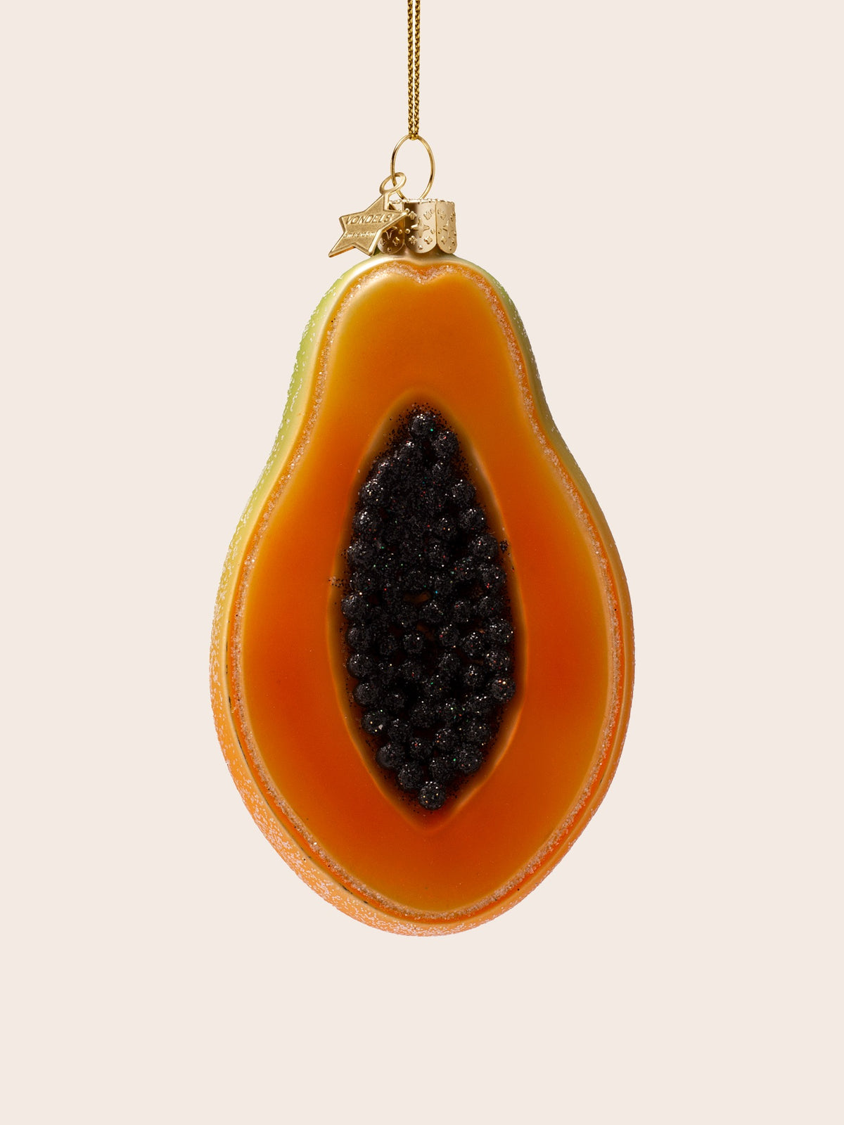 Front view of the cut papaya ornament showing the central cavity filled with dark beaded seeds