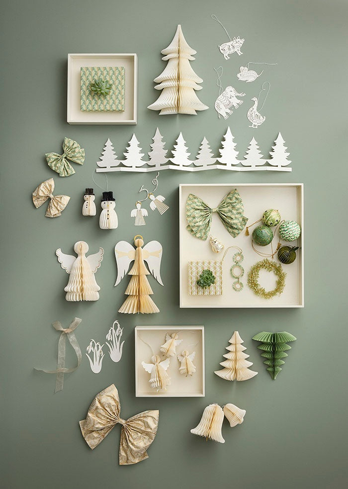 The cream and gold bow displayed among festive paper ornaments, angels and trees