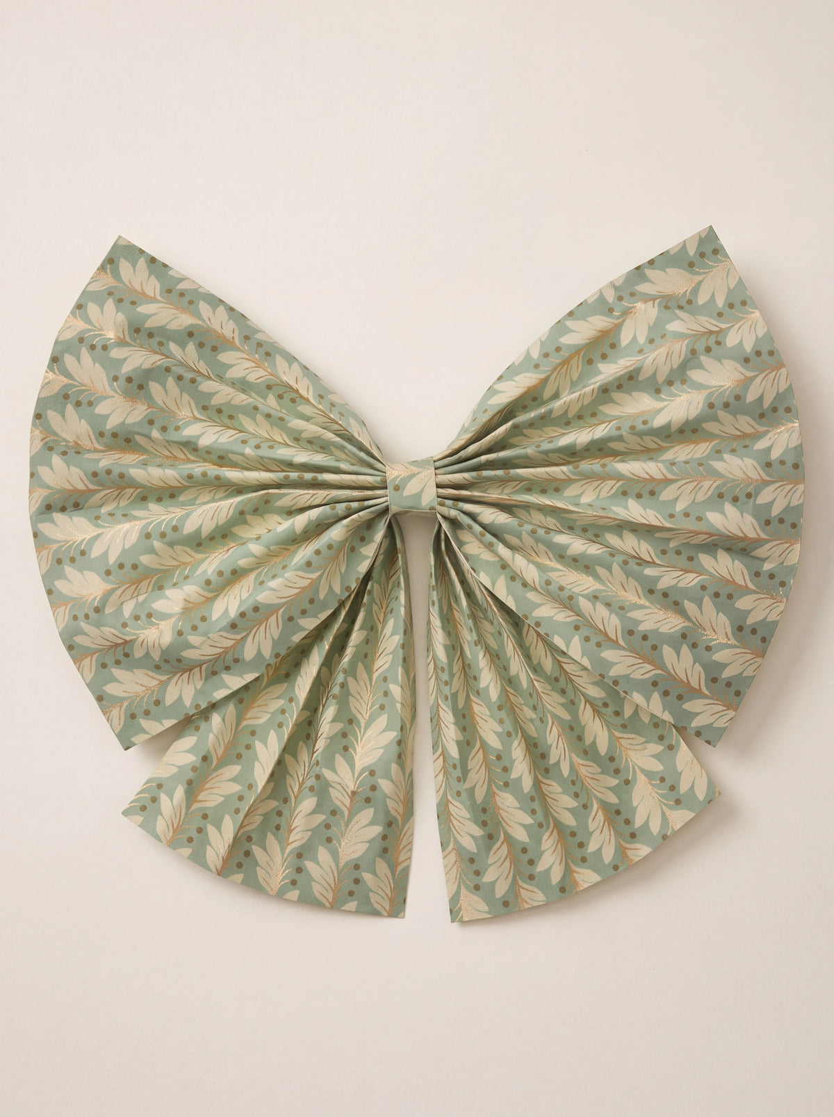 Pleated paper bow in sage green featuring a gold botanical leaf pattern