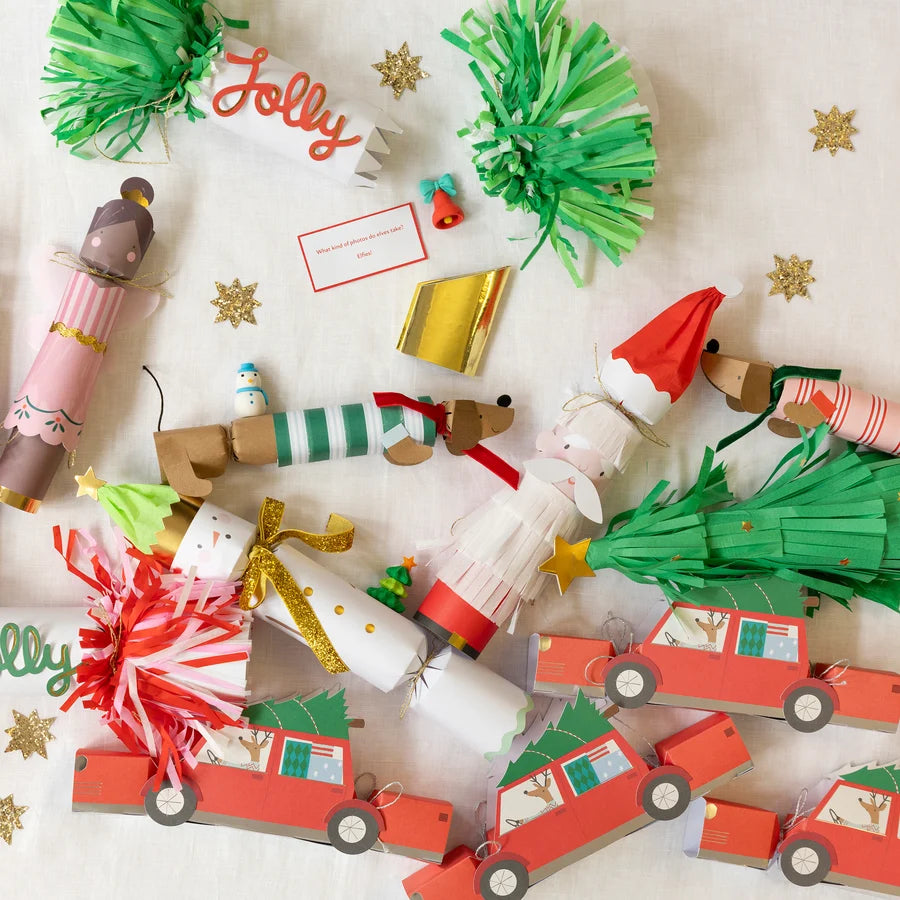 Paper Christmas crackers including the Santa and tree designs laid out among other novelty crackers and jokes