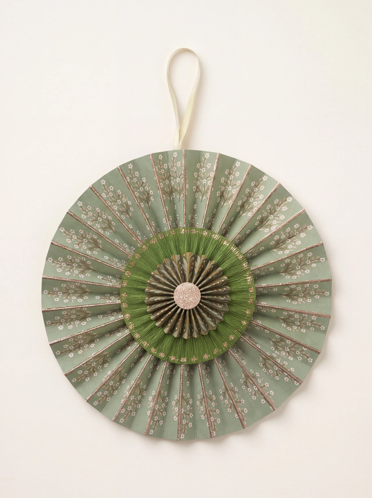 Layered cotton paper rosette in sage green floral print with pleated tiers, glitter details and hanging ribbon