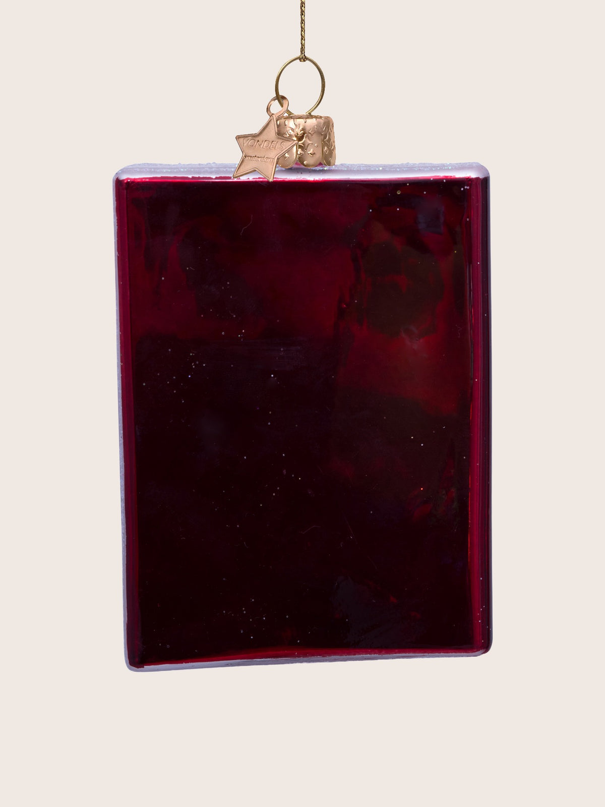 Glossy deep red reverse side of the glass passport ornament with subtle glitter specks