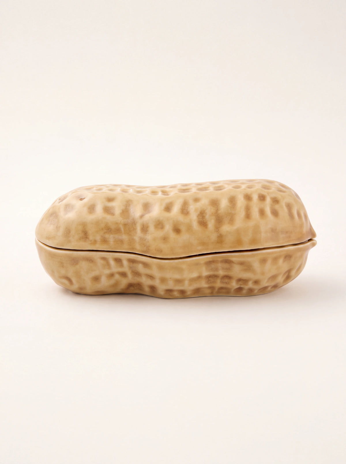 Peanut-shaped box in glazed tan earthenware with a textured shell surface and closed lid