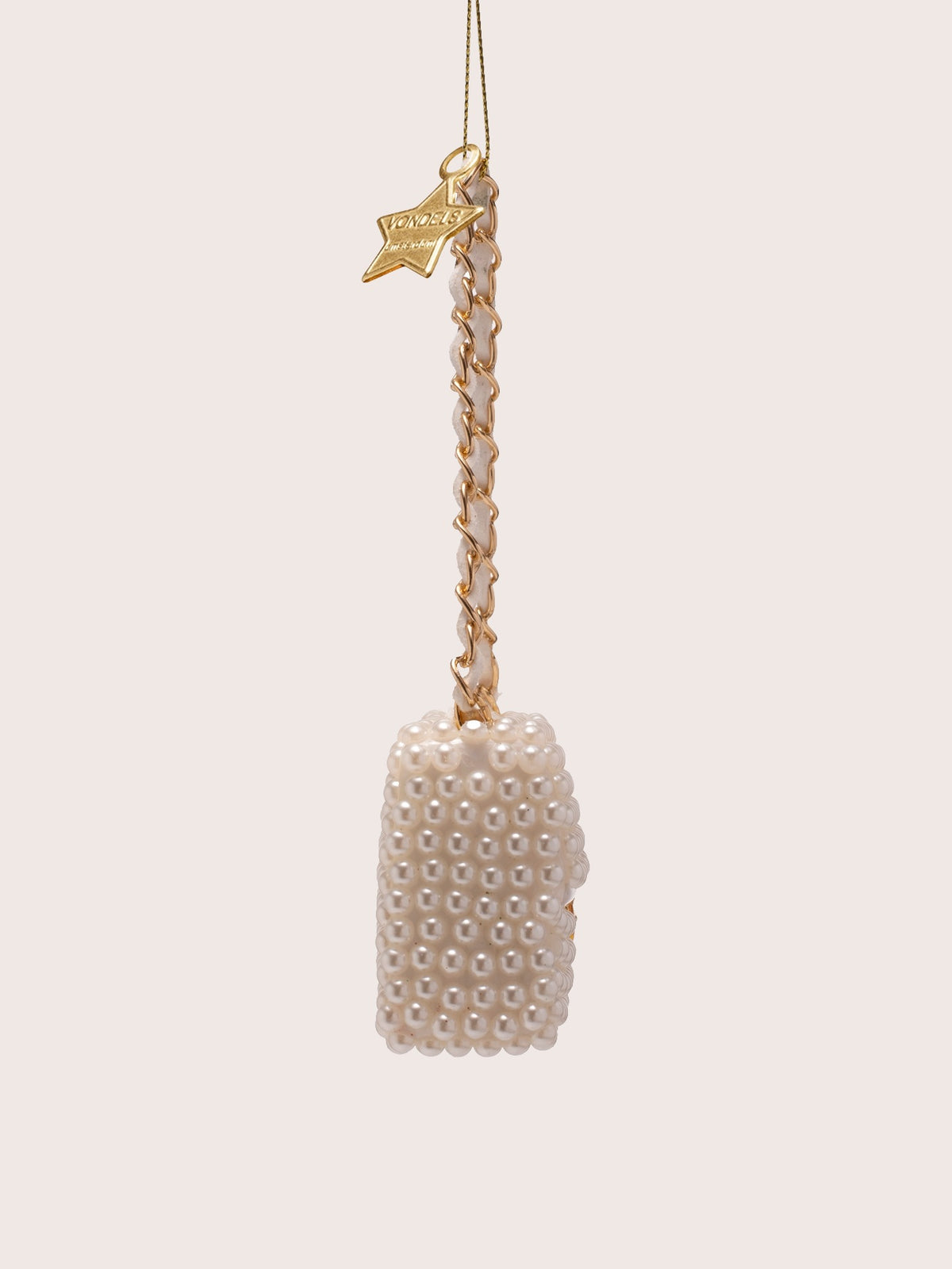 Side view of the pearl handbag ornament showing its thickness and beaded profile