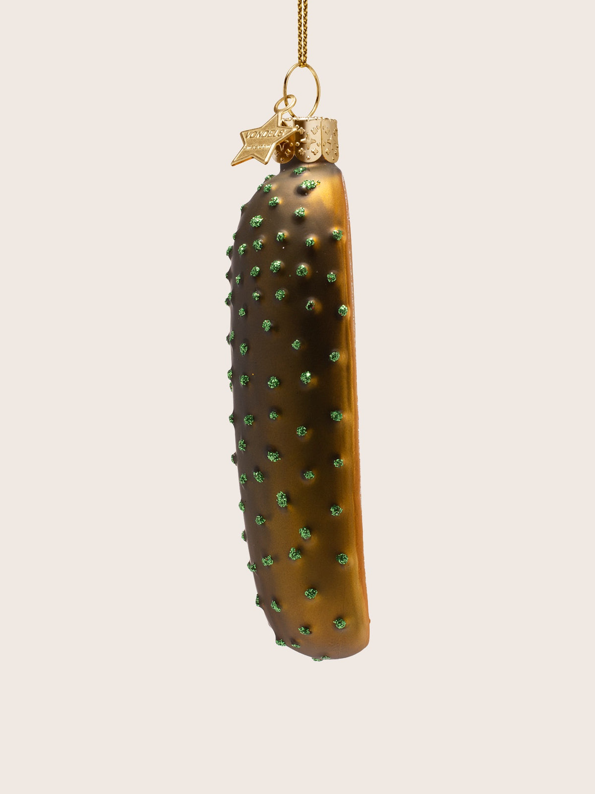Side view of the glass ornament showing the rounded dark green exterior dotted with textured glitter studs