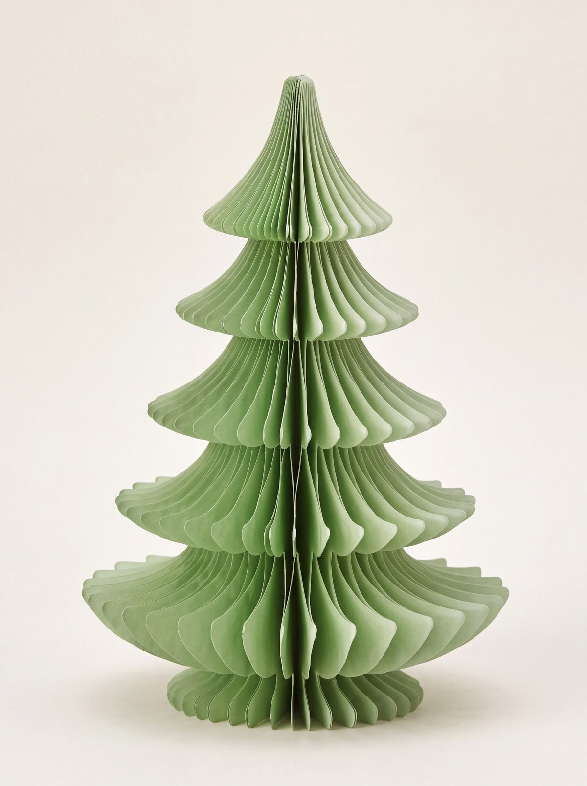 Green paper honeycomb tree with tiered, curved branches unfolding into a conical shape