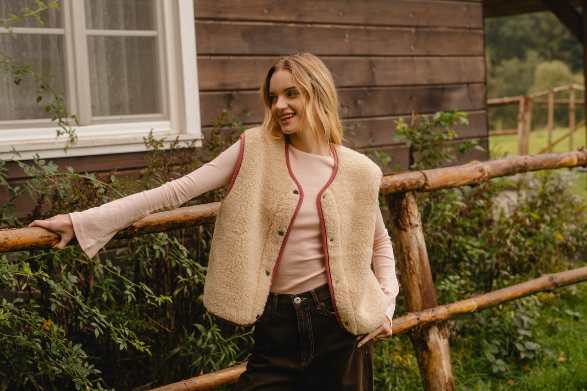 Unfastened wool vest worn layered outdoors, showing the draped fit from a slight distance