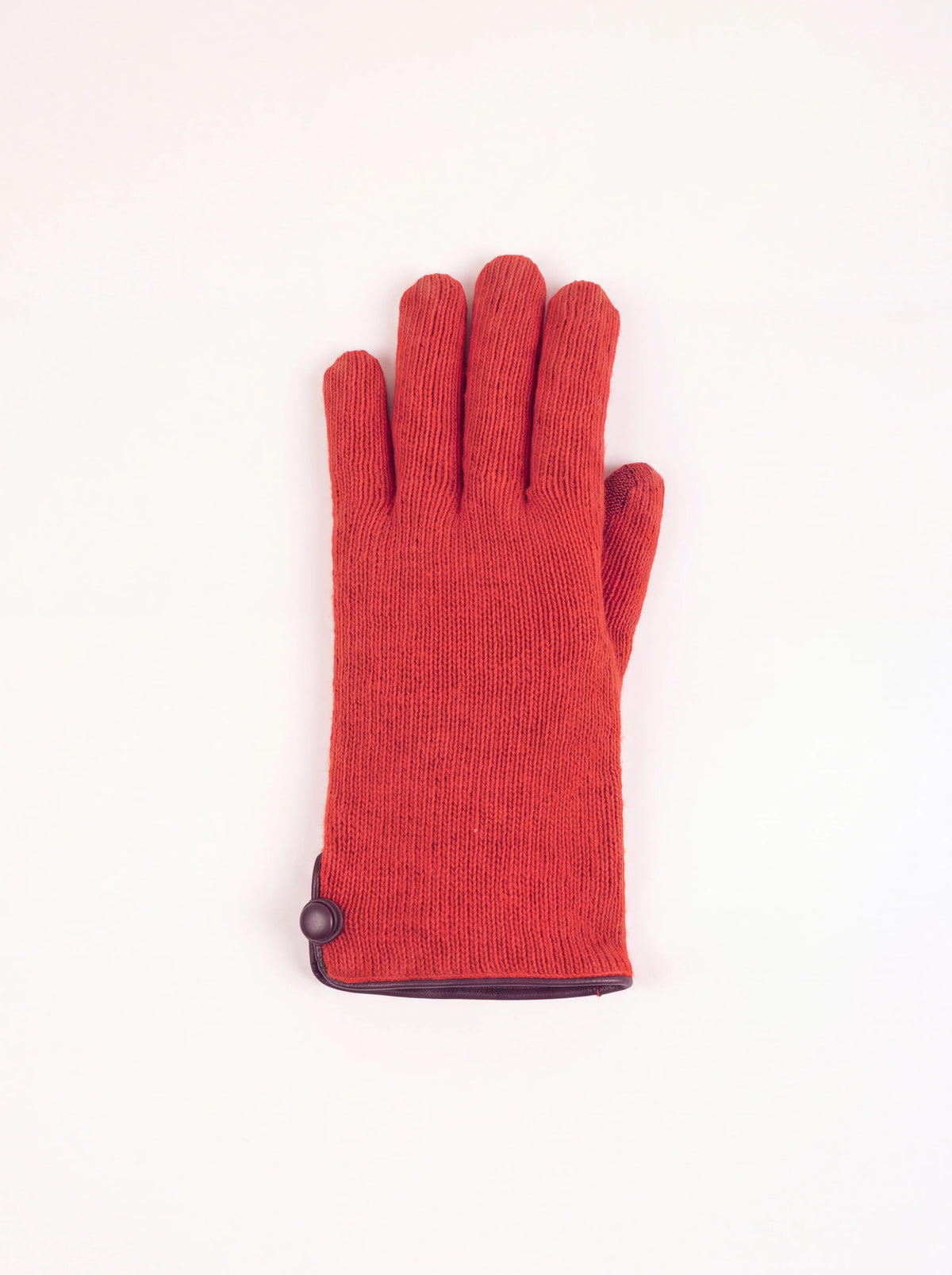 Terracotta knitted wool and cashmere glove with dark leather trim and a covered button at the cuff