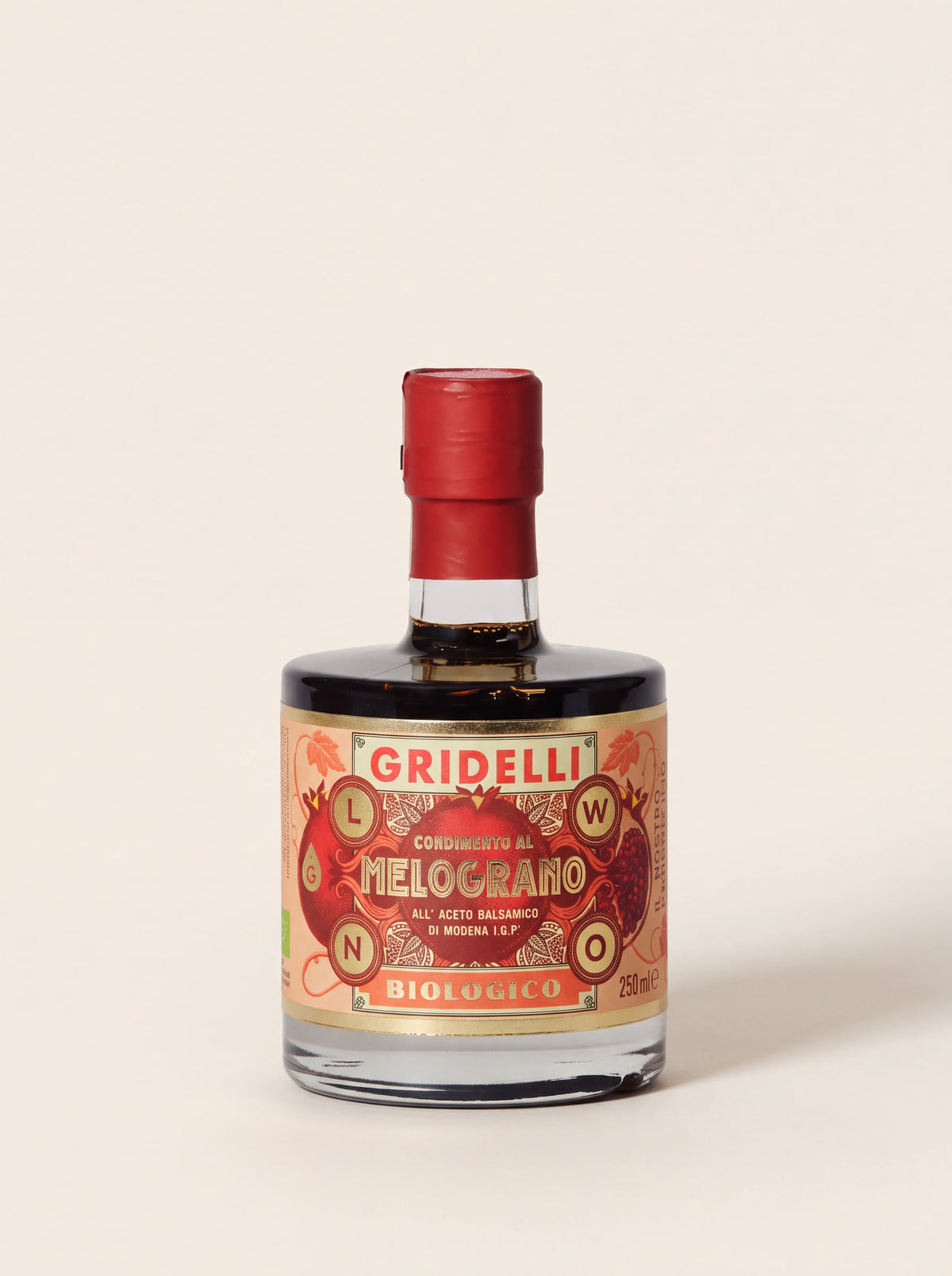Pomegranate balsamic vinegar in a round glass bottle with a red foil seal and illustrated label