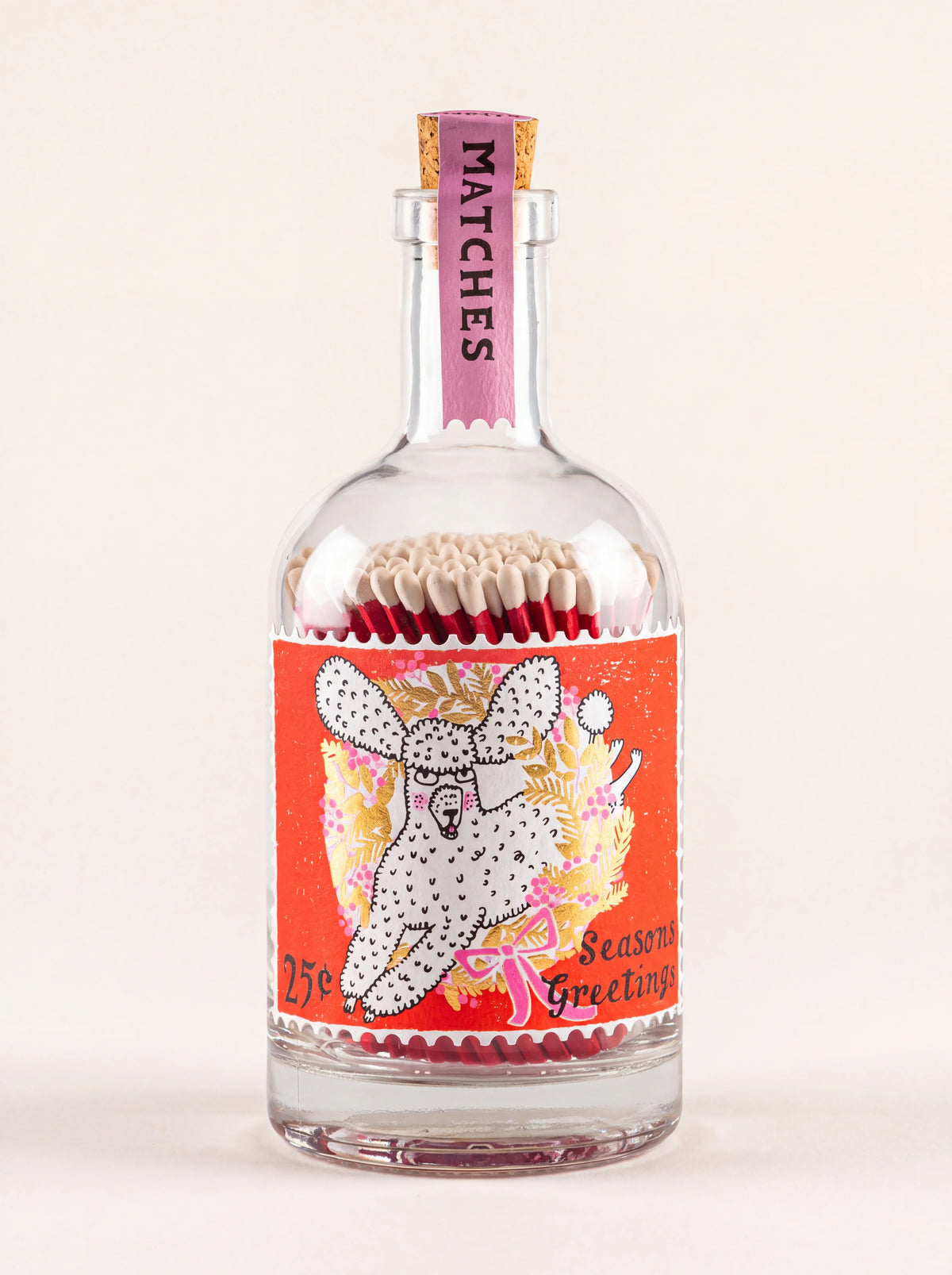 Glass match bottle with cork stopper and an illustrated poodle on a red stamp label reading Seasons Greetings