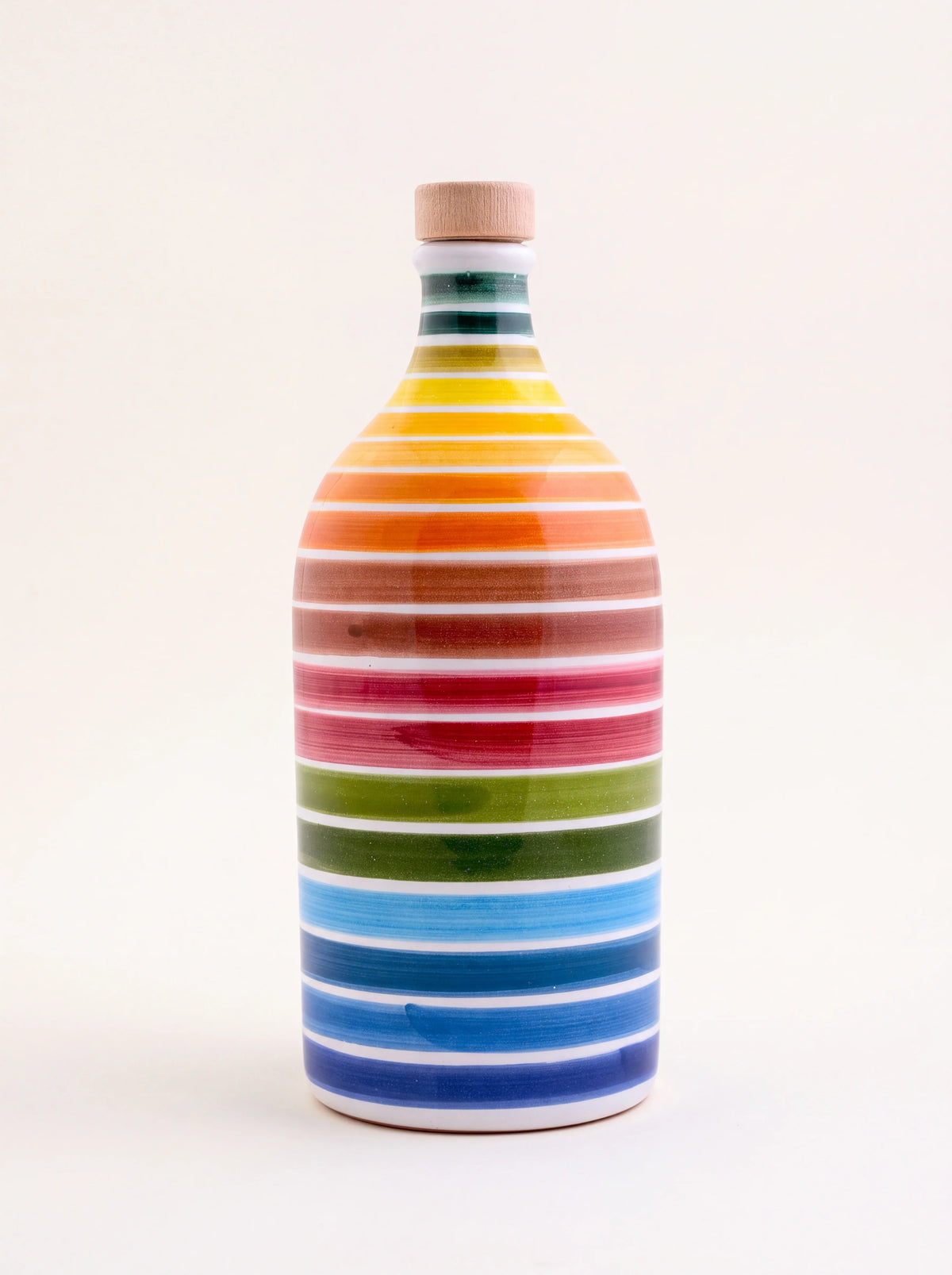 Ceramic olive oil jar with horizontal rainbow stripes and a cork-topped stopper
