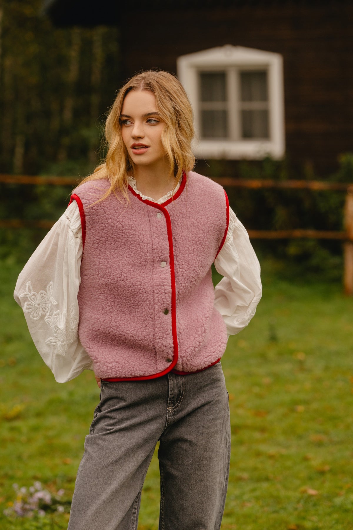 Pink wool vest with sheepskin texture, red bound trim and snap-button fastenings