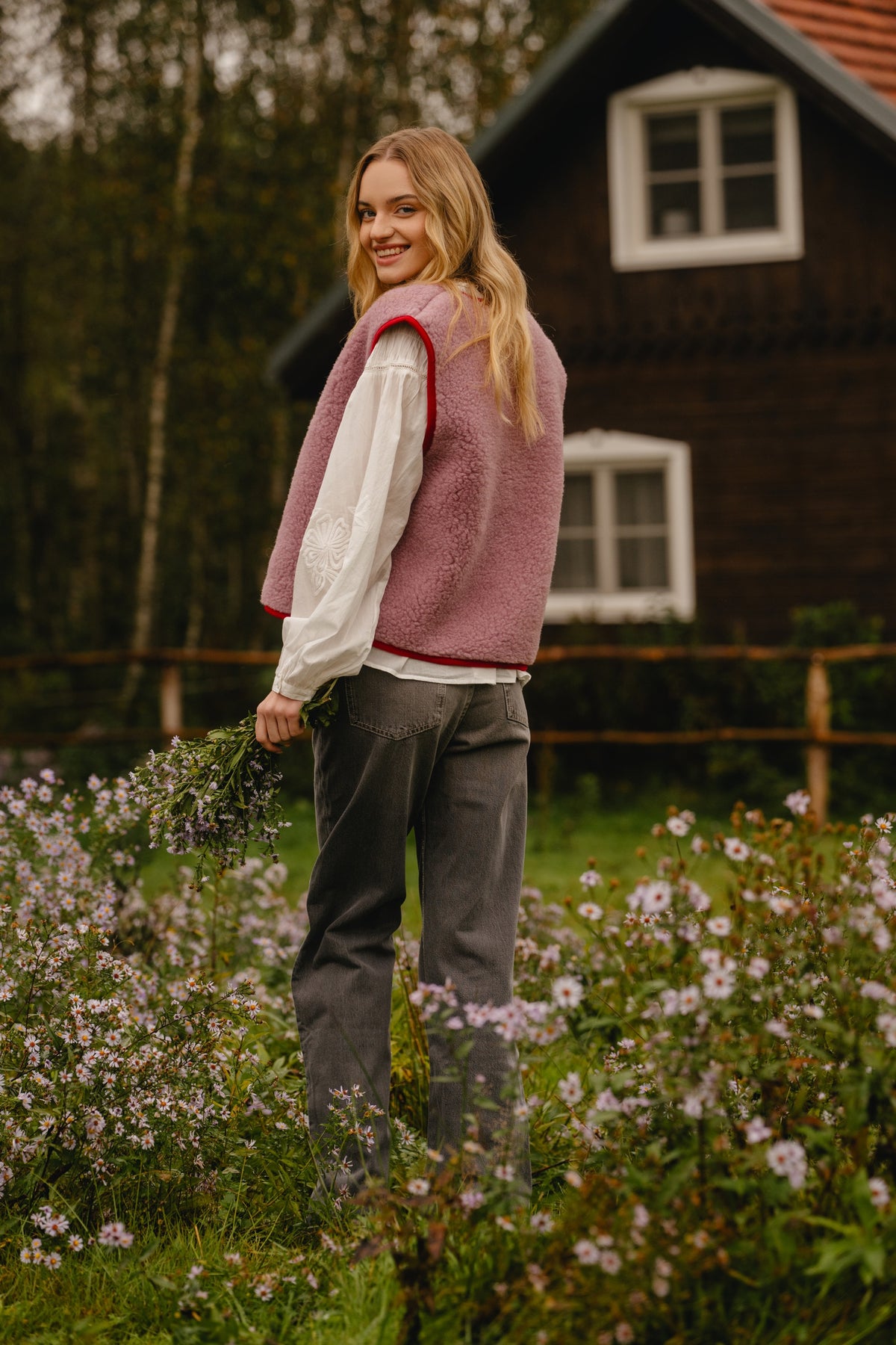 Rear view of the pink wool vest showing the plain fleece back with red edge binding