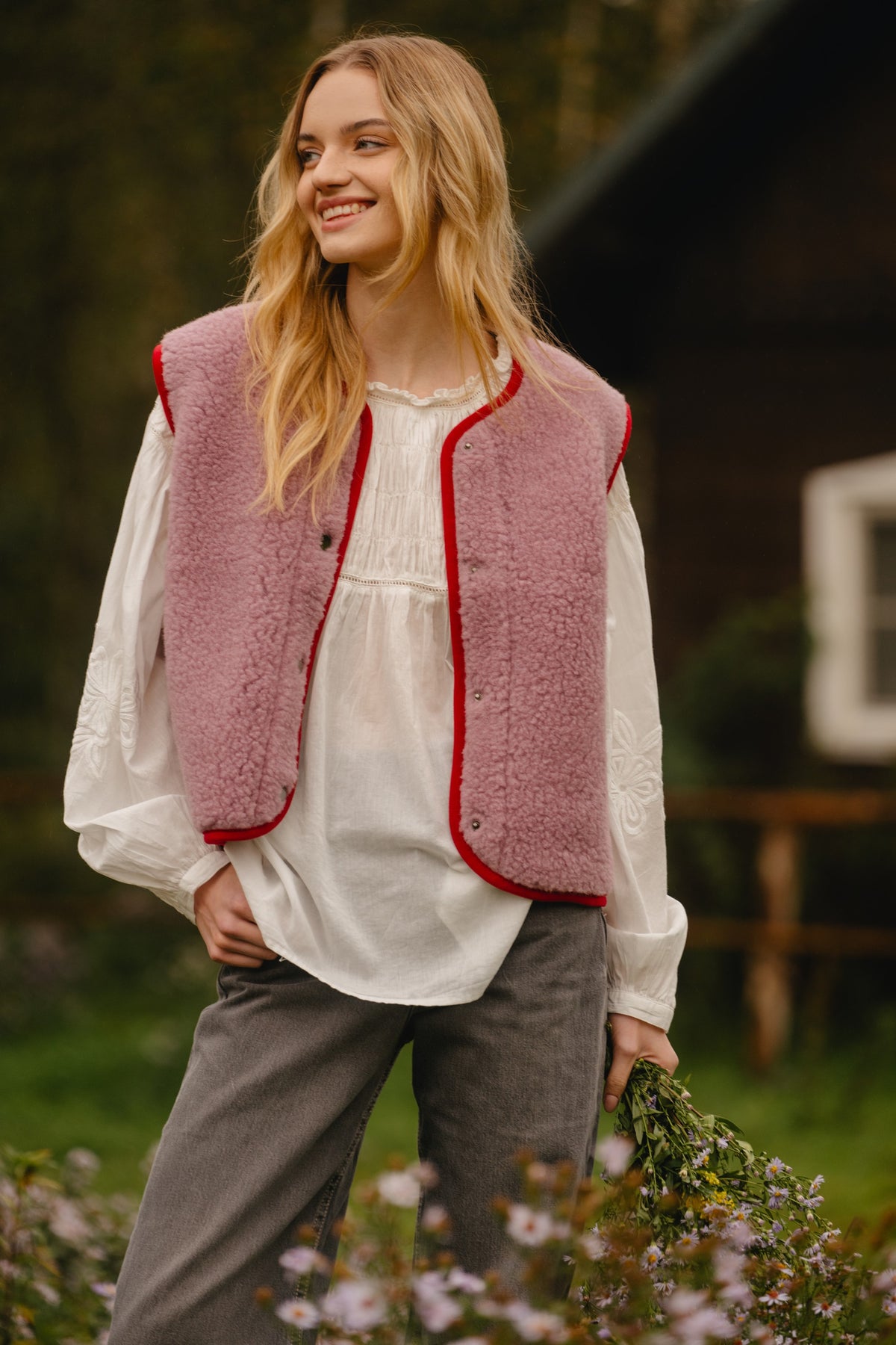 Close-up of the sheepskin-style wool texture and metal snap buttons along the red trim
