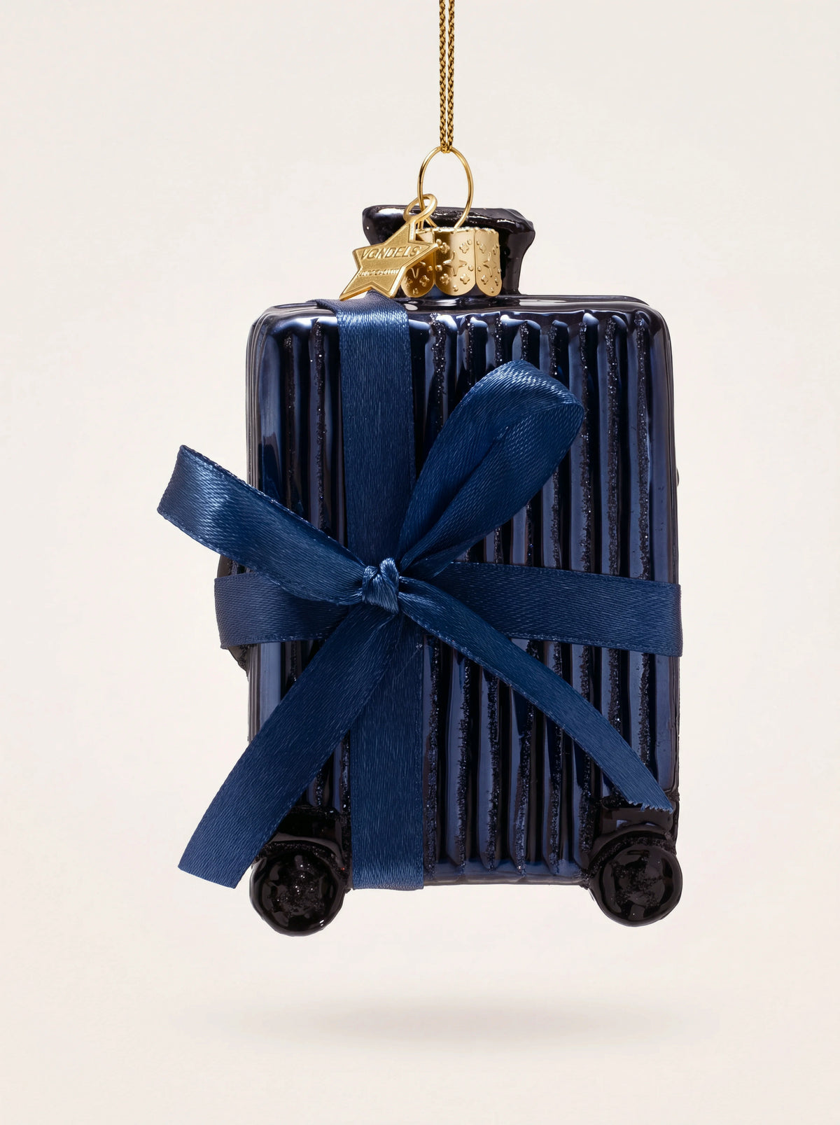 Blue ribbed glass suitcase ornament tied with a navy ribbon bow and gold hanging loop
