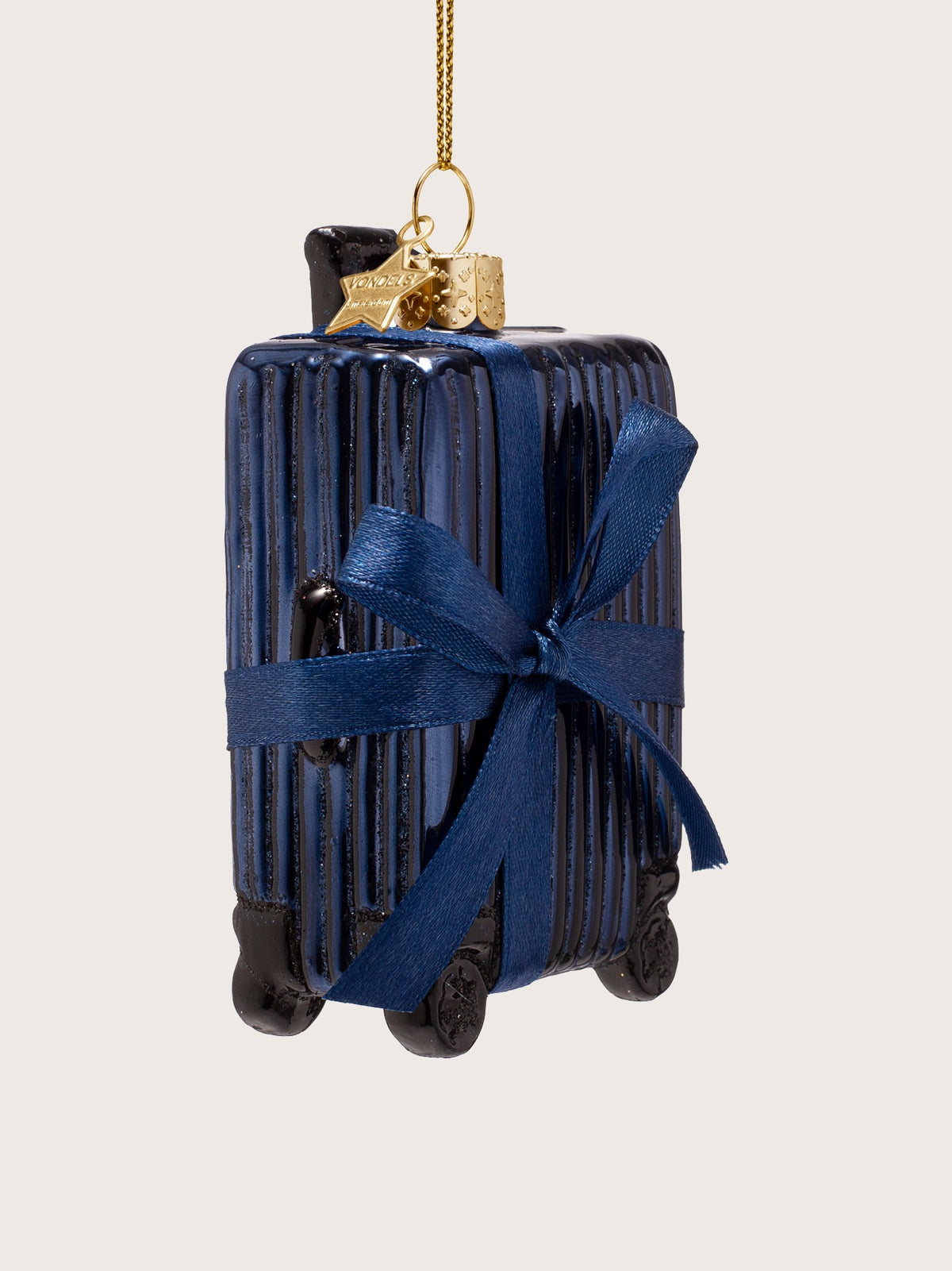 Ribbed suitcase ornament seen at an angle, displaying the depth, top handle and black wheels