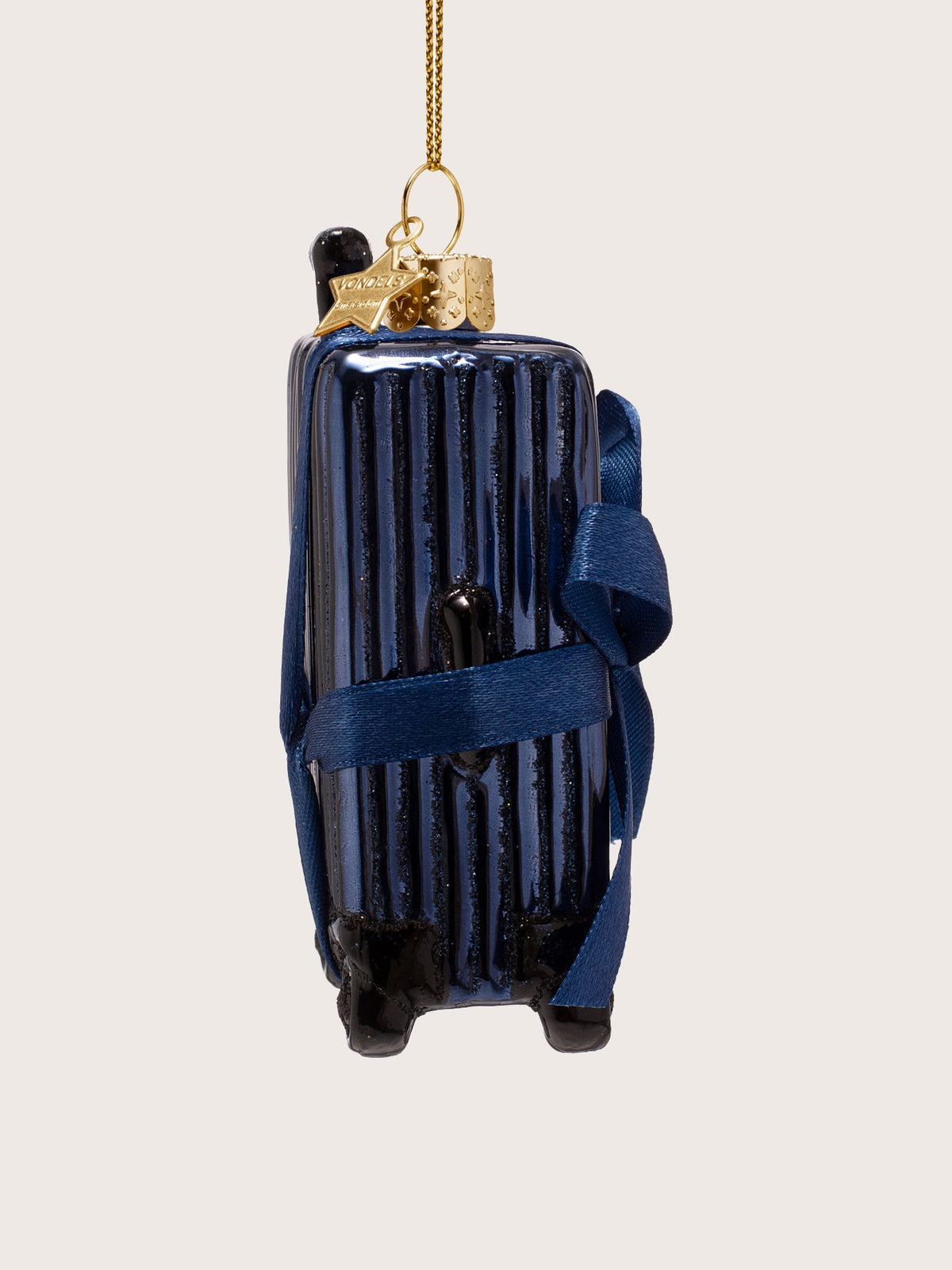 Ribbed suitcase ornament in side profile, showing the black carry handle and wrapped ribbon