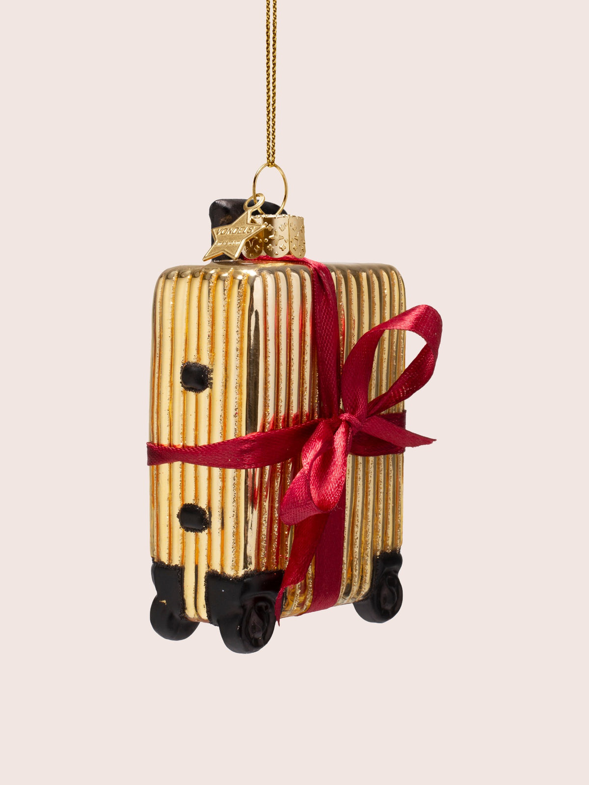 Three-quarter view of the gold suitcase ornament showing its side profile and black feet