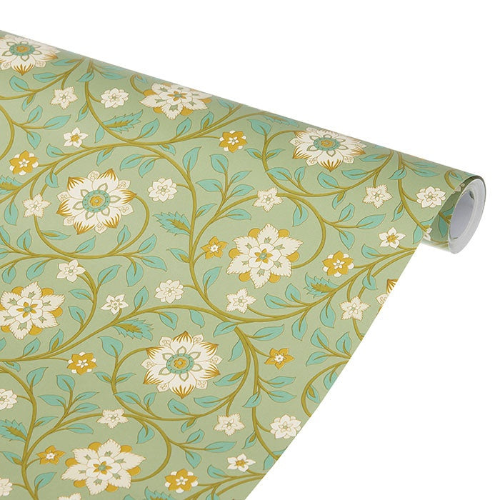 Sage-green wrapping paper roll partially unrolled, featuring stylised floral blossoms and leafy vines