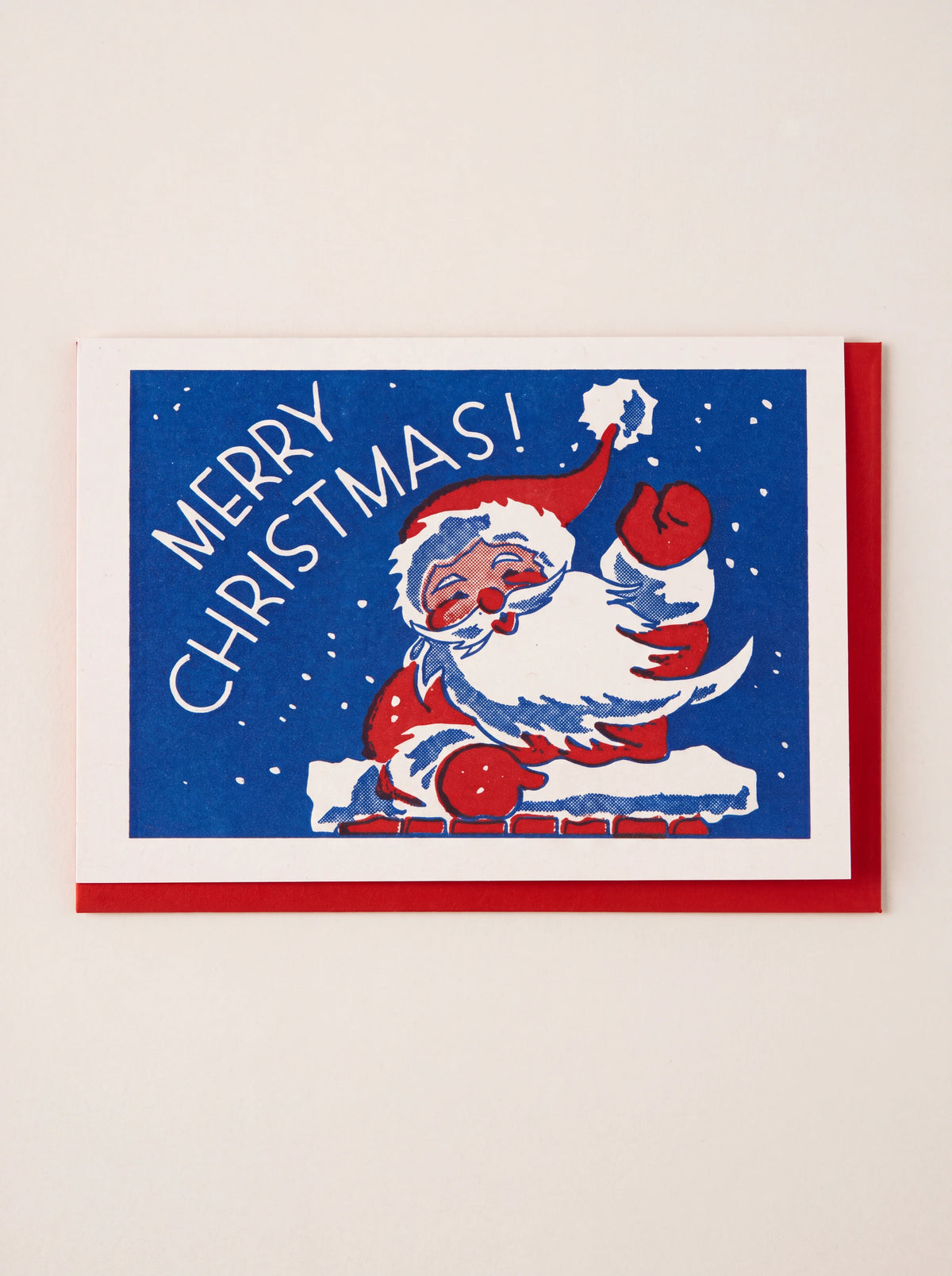 Christmas card reading 'MERRY CHRISTMAS!' with Father Christmas waving from a chimney, over a red envelope