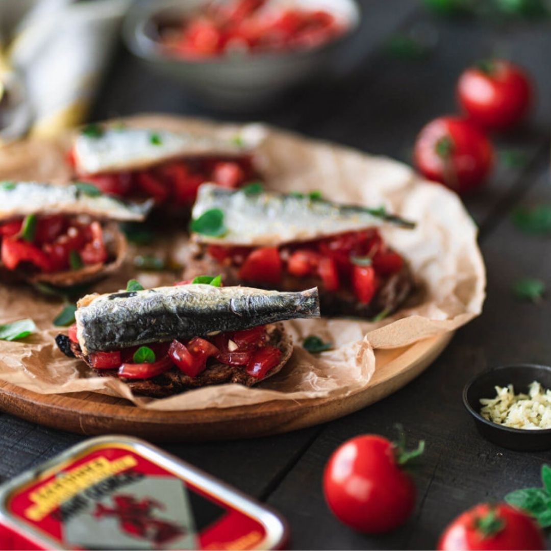 Whole sardines served over chopped tomatoes on slices of toasted bread