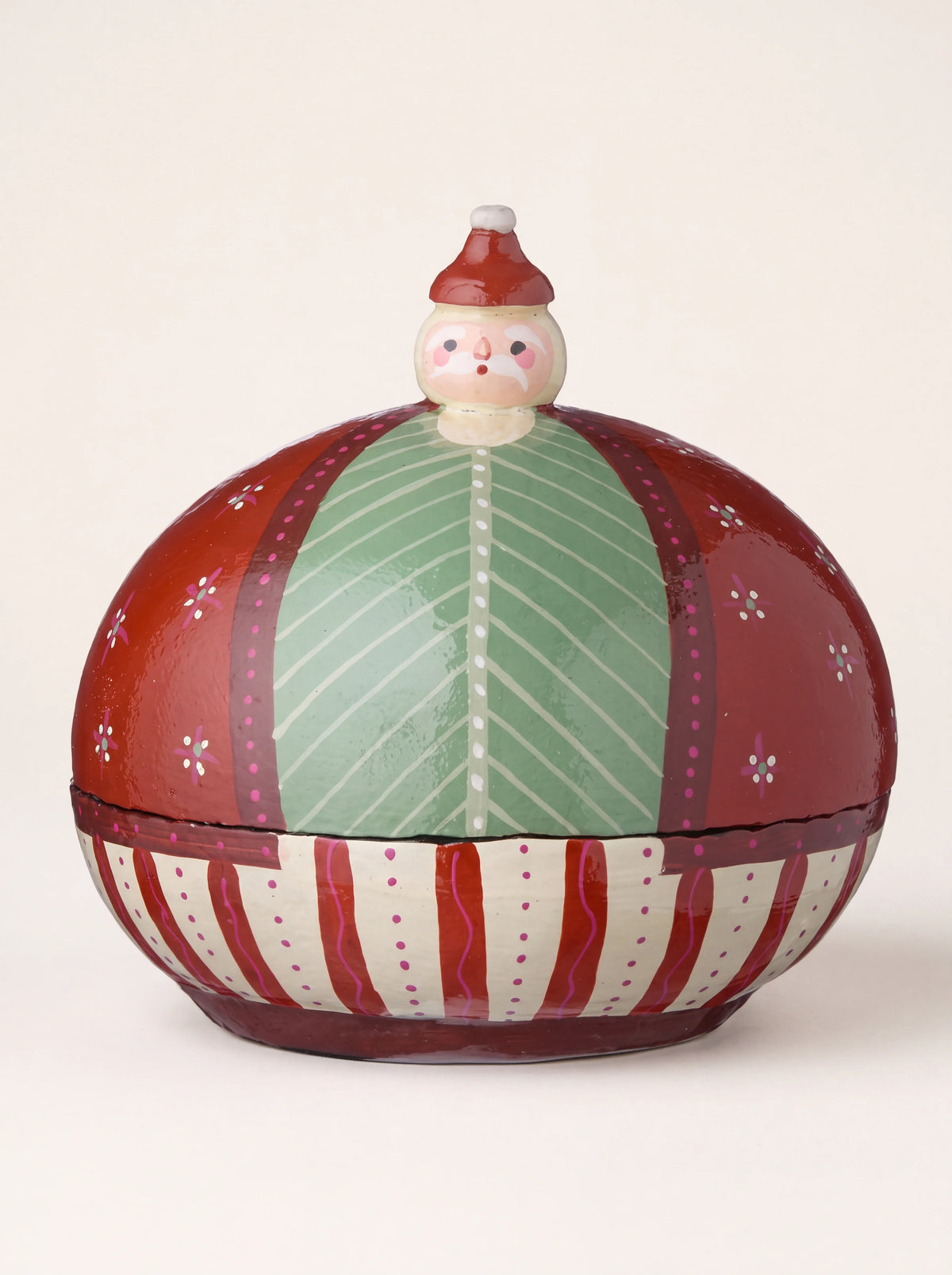 Round paper mâché box with a painted Santa head finial, ruby red dome lid, and striped base