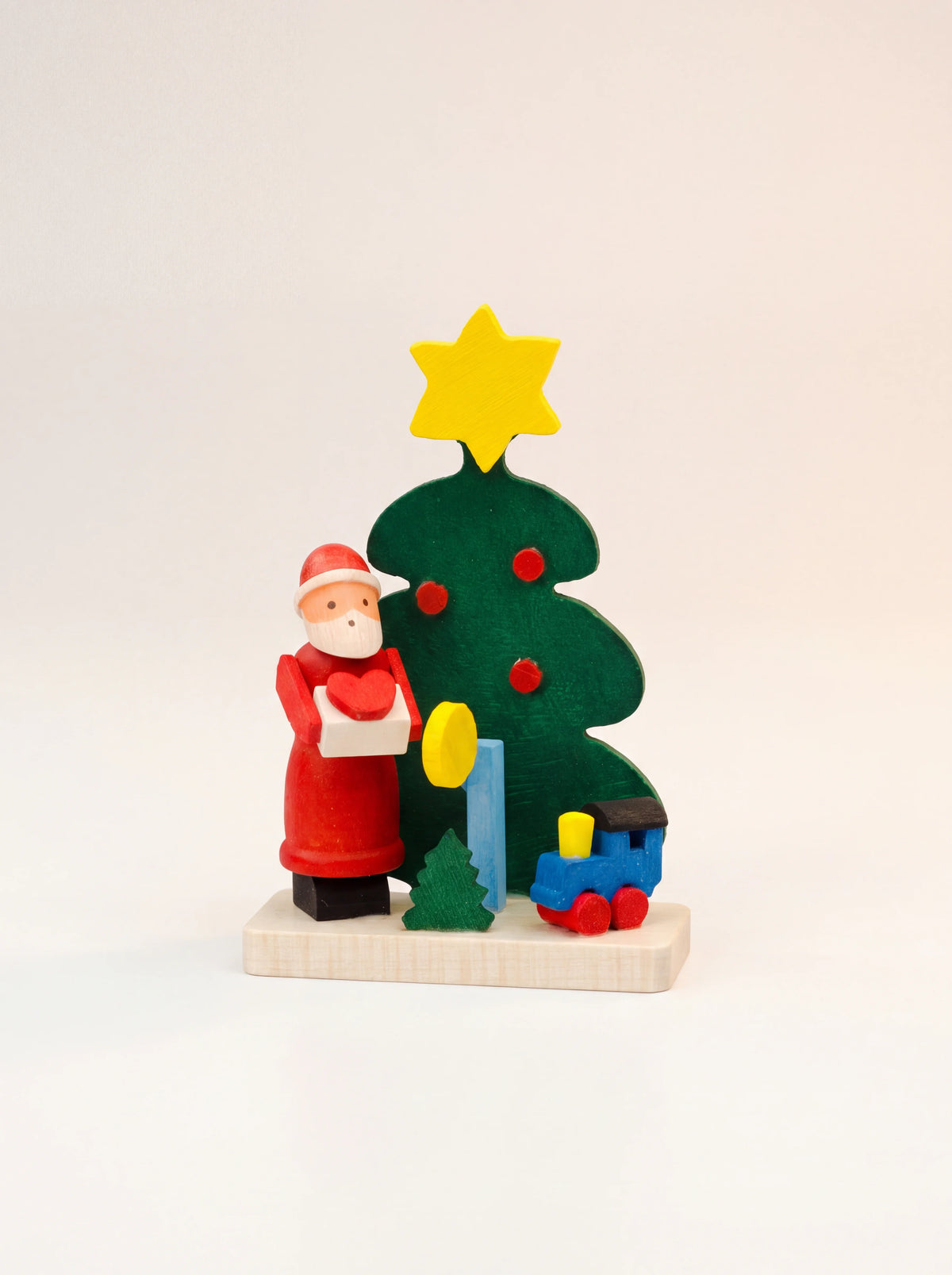 Hand-painted sycamore wood Christmas ornament with a Santa figure, star-topped tree and miniature toy train