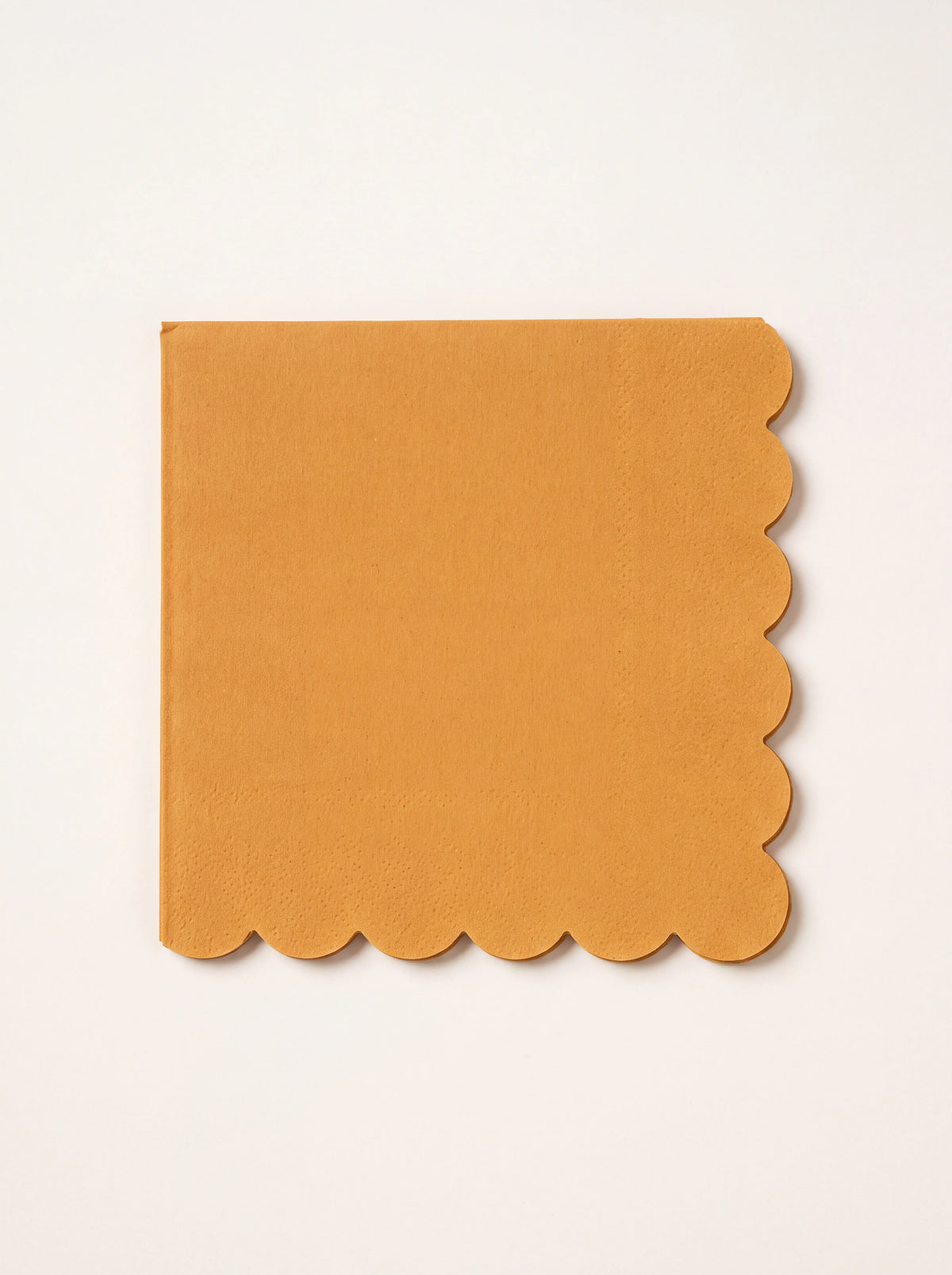 Square harvest yellow paper napkin folded with scalloped edges on two sides