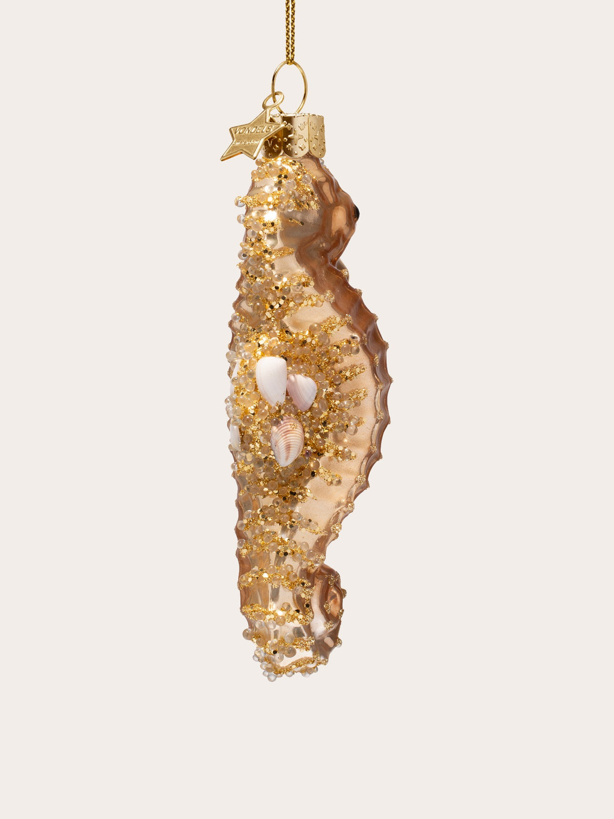 Rear view of the gold seahorse ornament showing the encrusted bead detailing and small shells