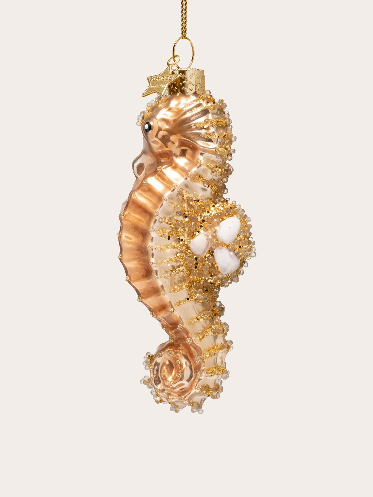 Opposite side profile of the gold glass seahorse ornament showing the ridged belly and curled tail