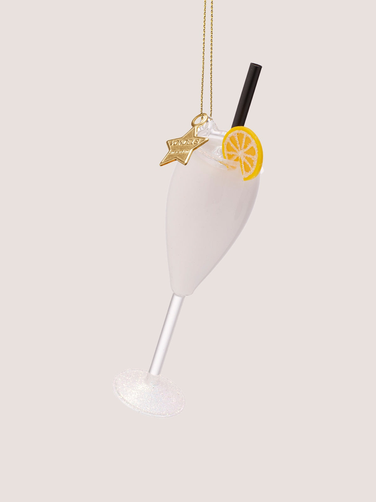 Cocktail ornament angled forward showing the glitter-dusted circular base and gold star charm