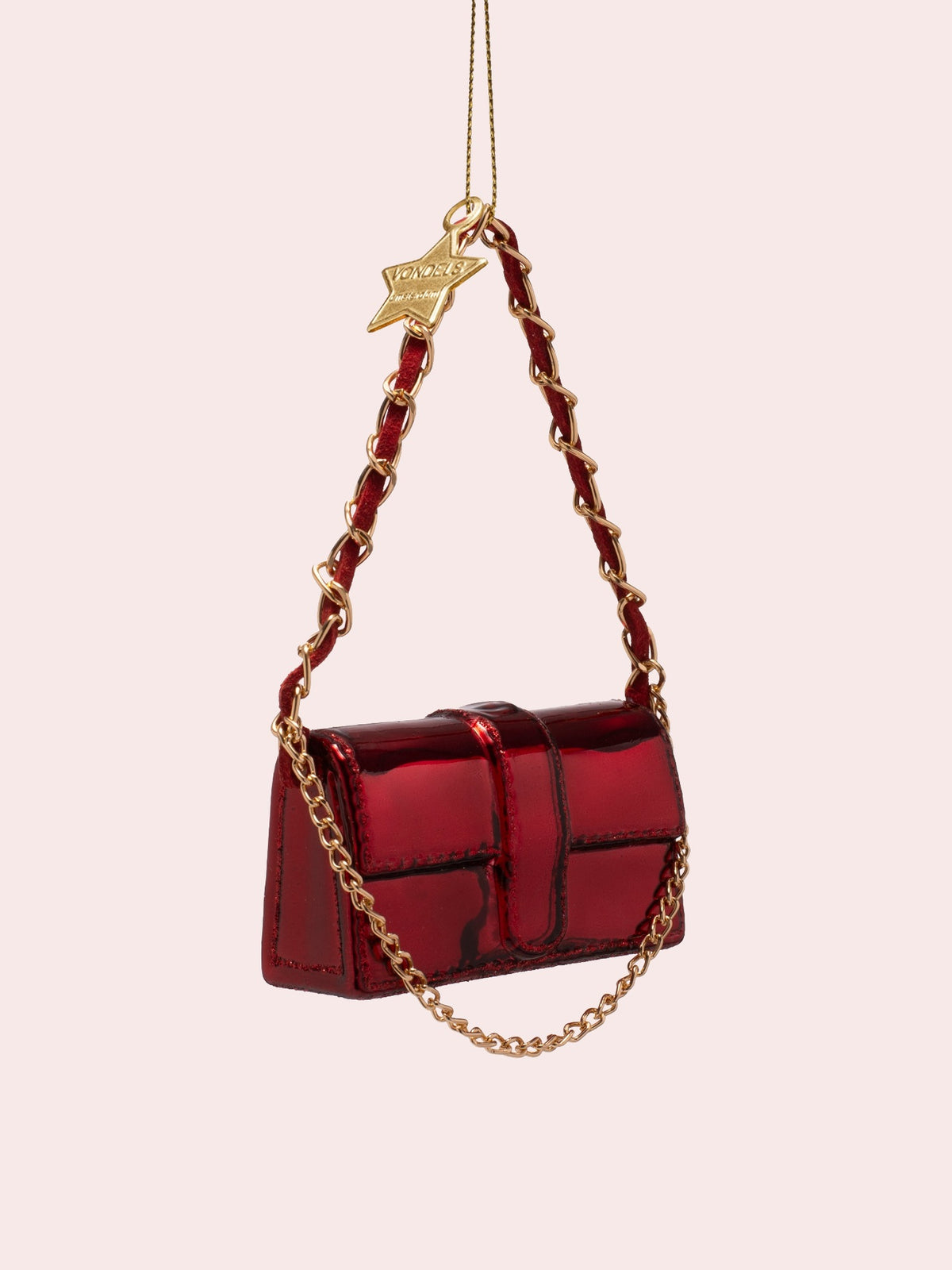 Three-quarter view showing the front flap and depth of the glossy burgundy handbag ornament