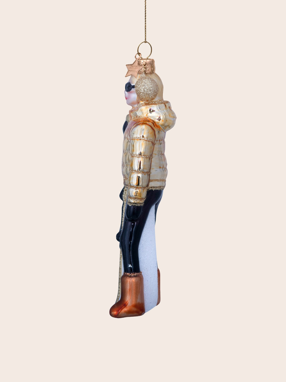 Side profile showing the jacket hood, puffer ridges and bronze-toned ski boots