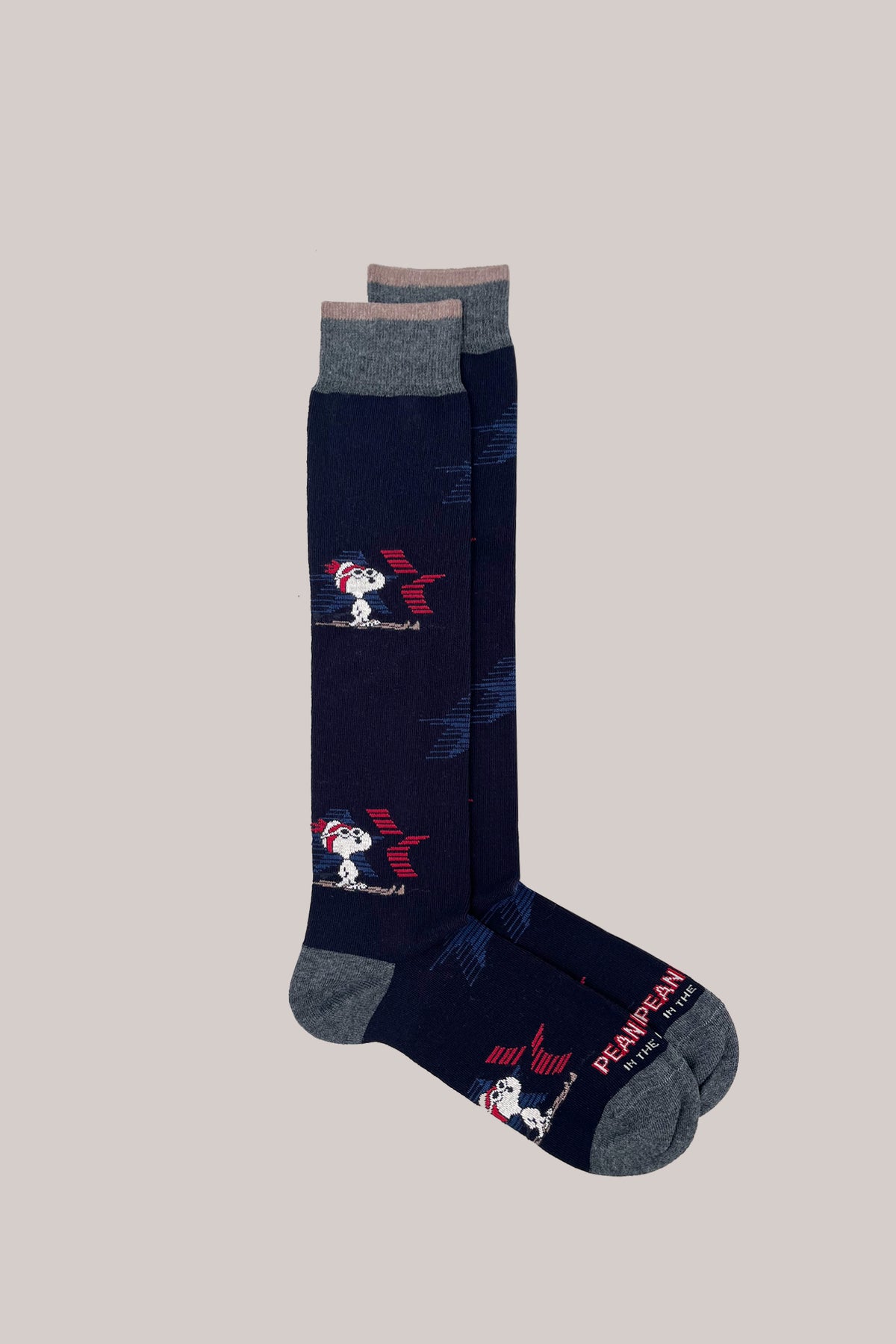 Dark blue knee-high socks featuring skiing Snoopy motifs with grey ribbed cuffs, heels, and toes