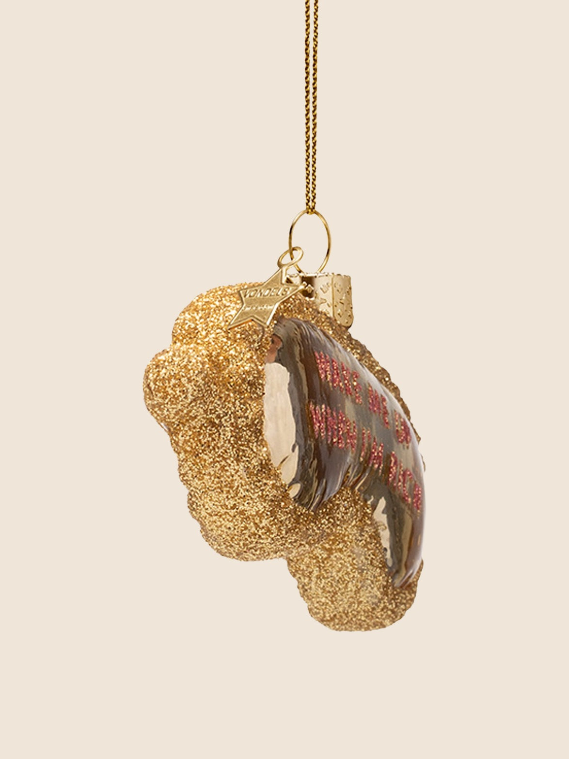 Side view of the glass sleeping mask ornament showing its curved profile and glitter border