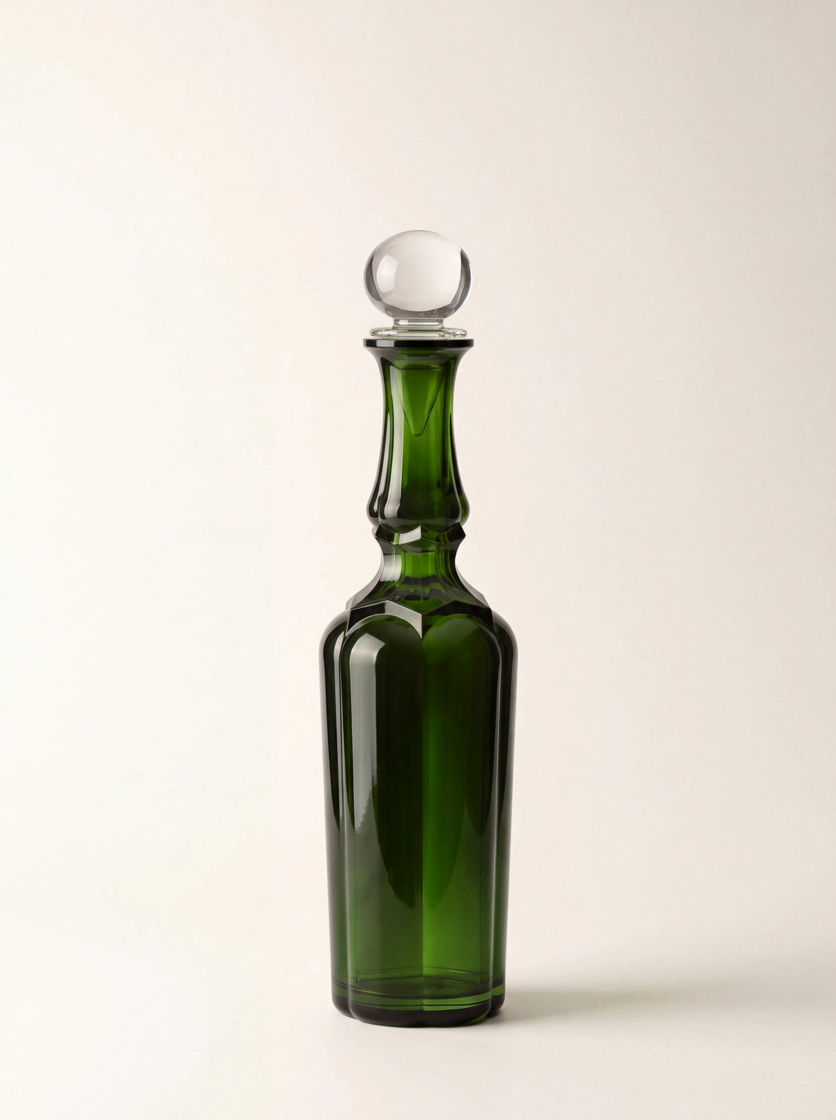 Green acrylic bottle with a faceted body, contoured neck and clear spherical stopper