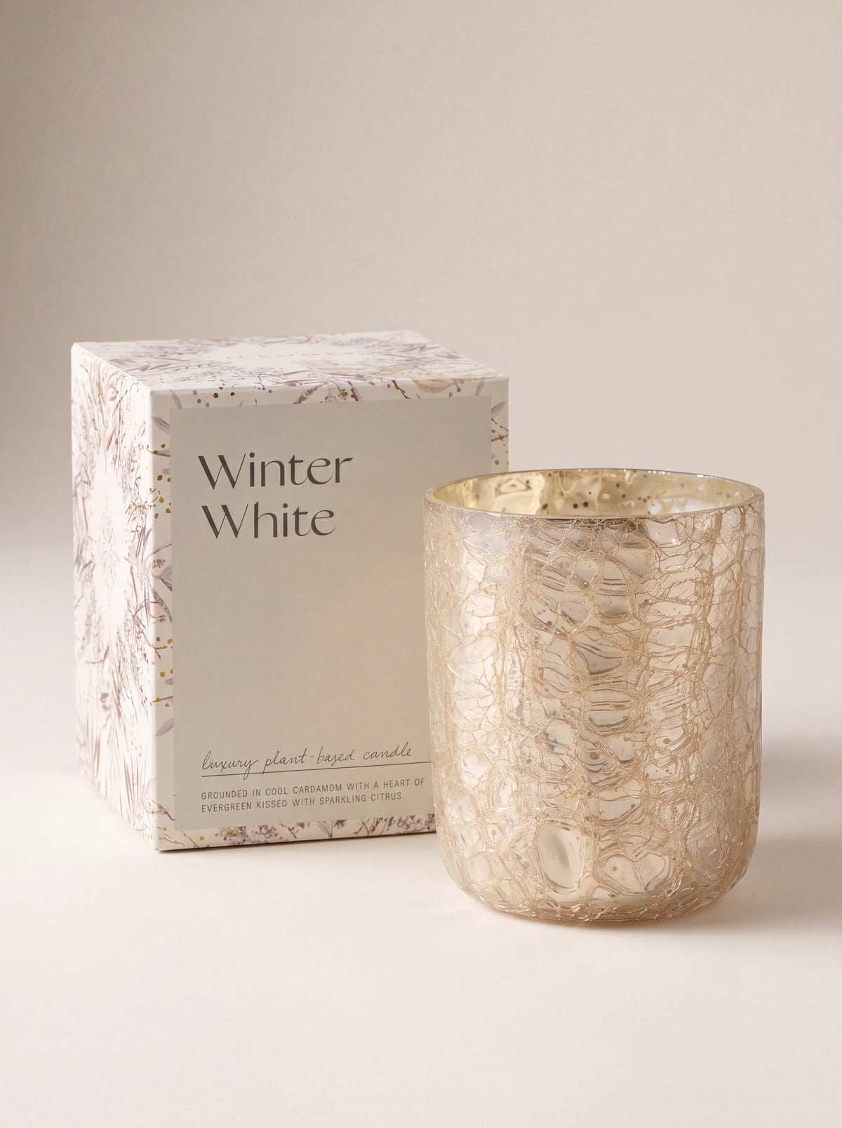 Gold crackle glass candle vessel next to its box reading Winter White luxury plant-based candle