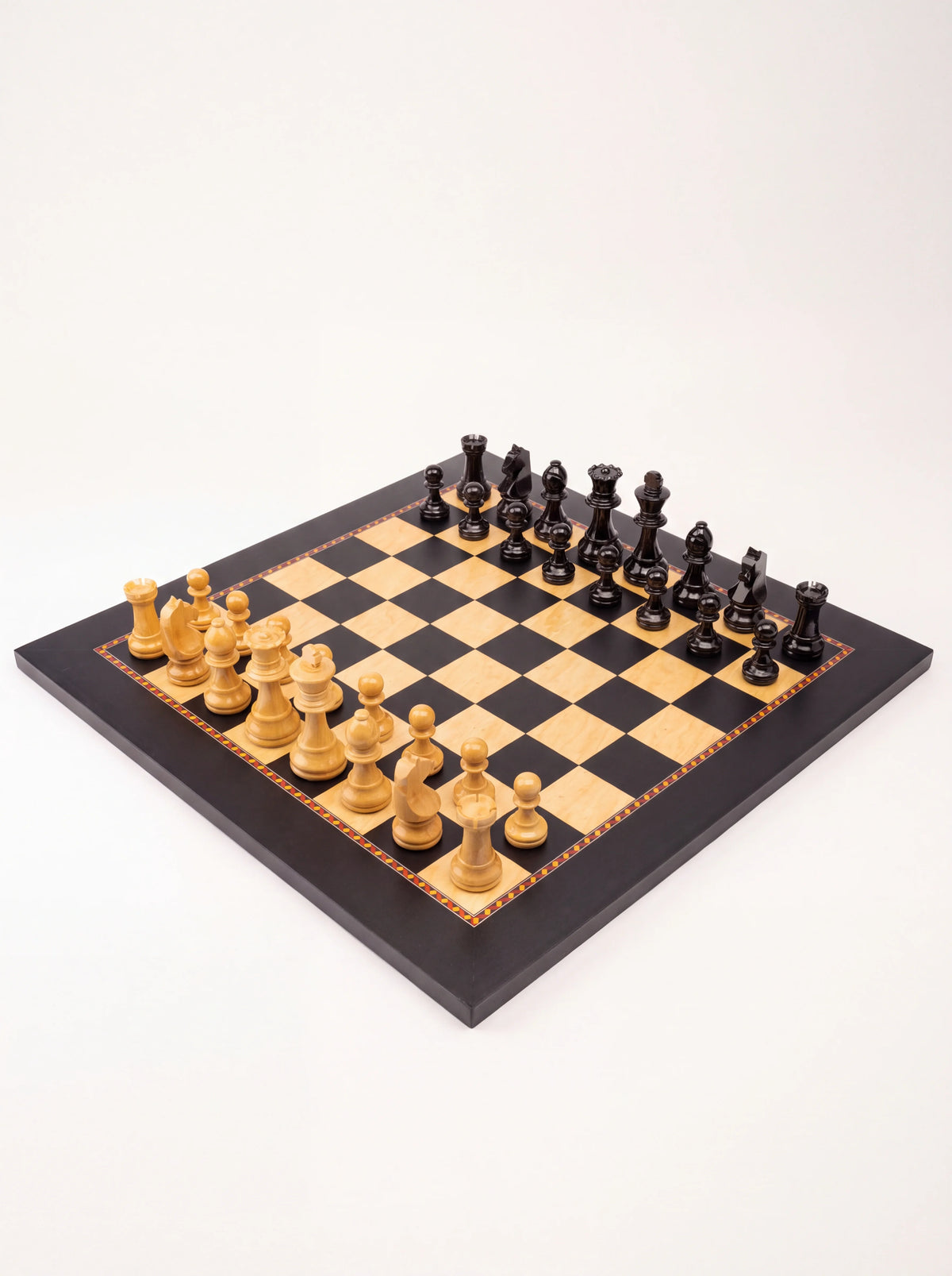 High-angle view of the wooden chess board displaying the decorative inlay trim and turned chess pieces