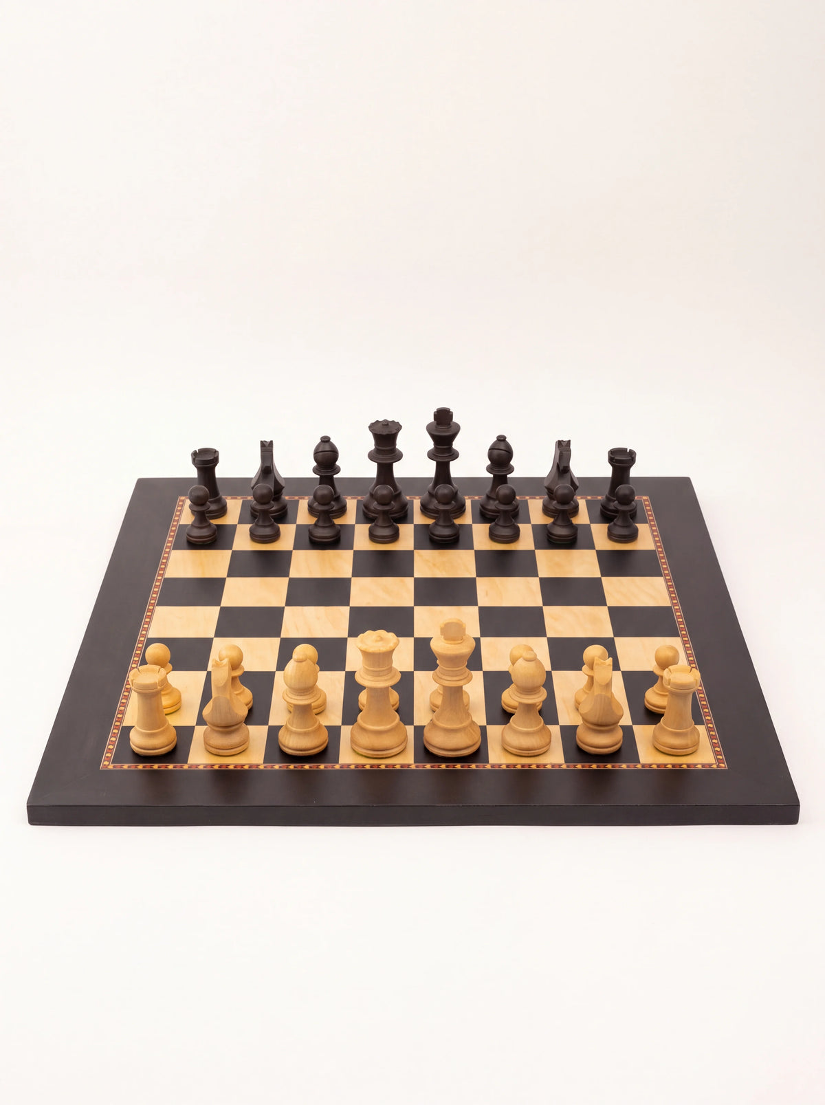 Front view of the chess board showing the silhouettes and relative heights of the carved wooden pieces