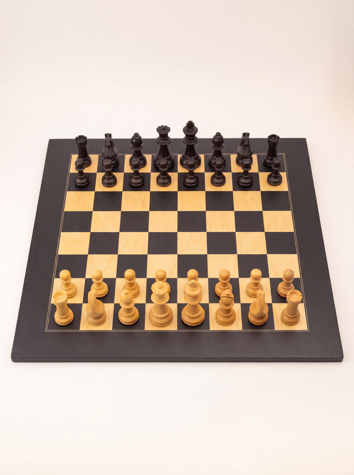 Matte Staunton chess set with black and natural wood pieces set up on a square chequered board