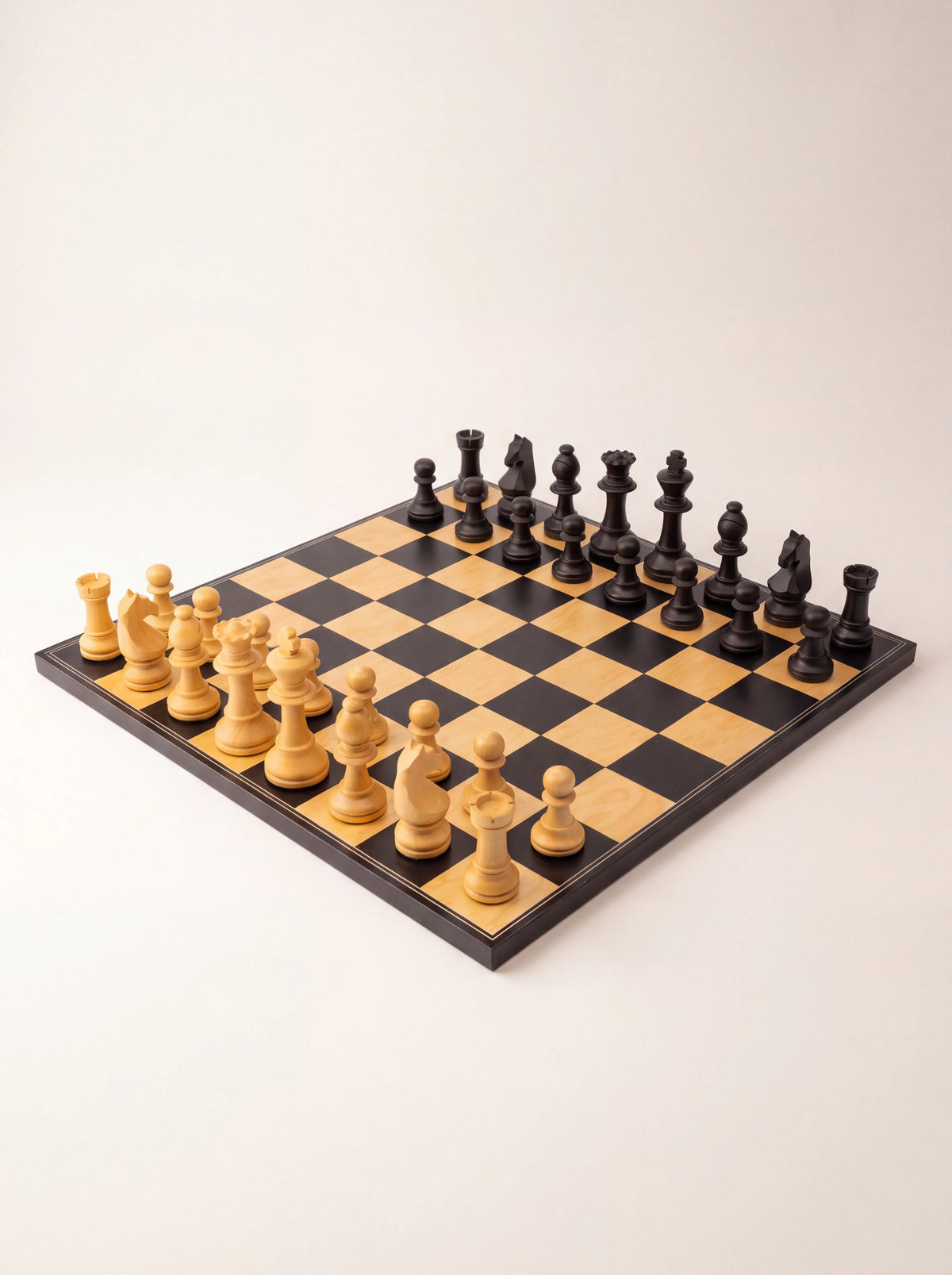 Staunton chess set with matte black and natural wood pieces arranged on a matching square chessboard