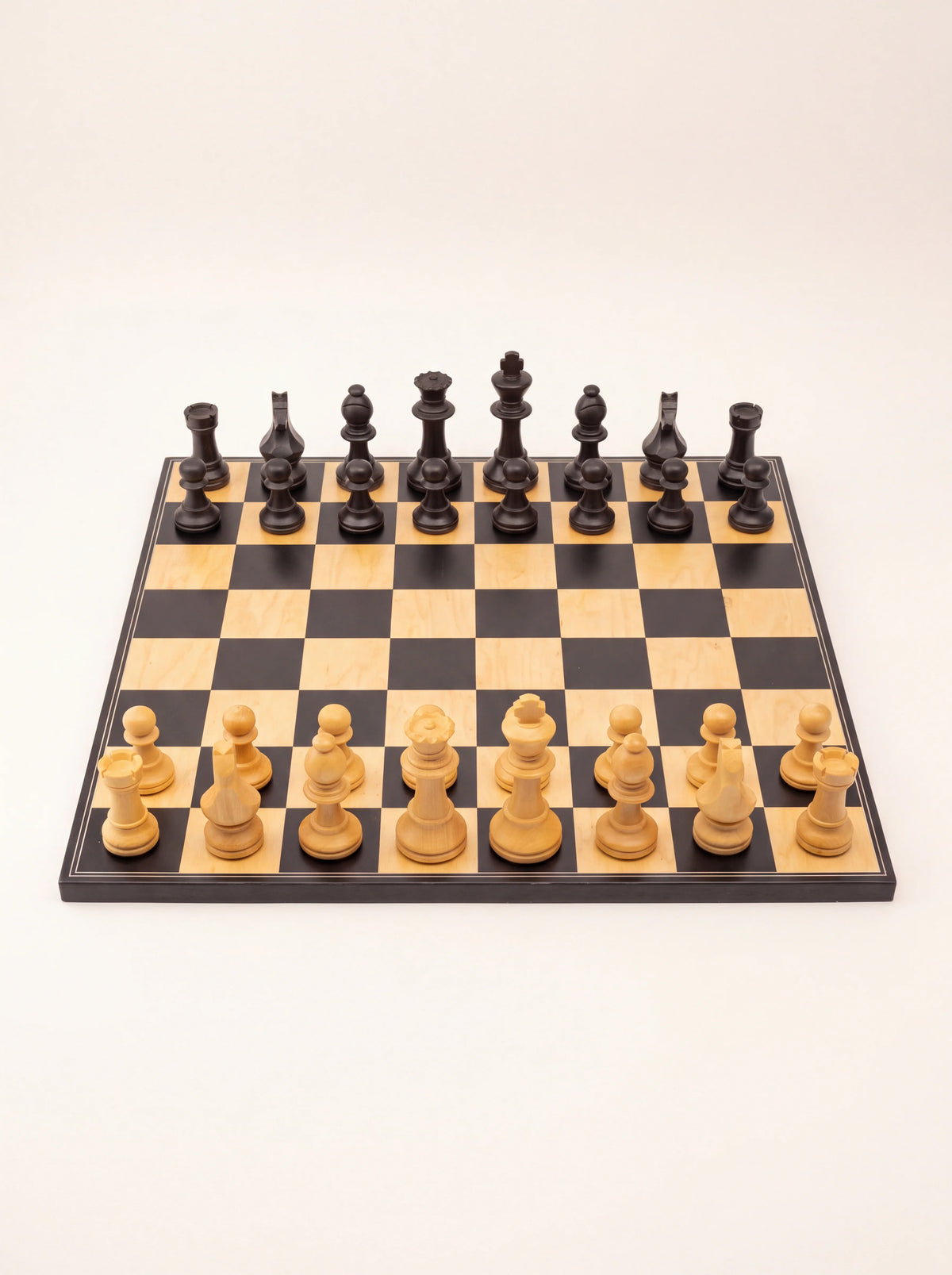 Front player view of the chessboard showing the rank of light pieces facing the black pieces opposite