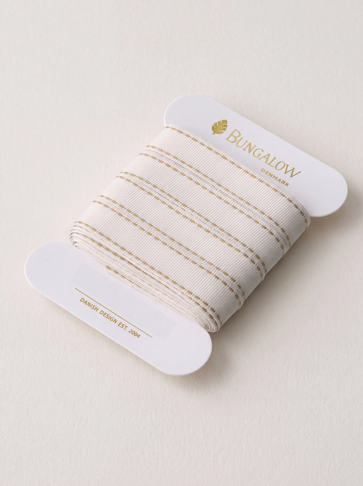 Ribbed off-white polyester ribbon with dijon yellow stitched stripes, wound on a white card spool