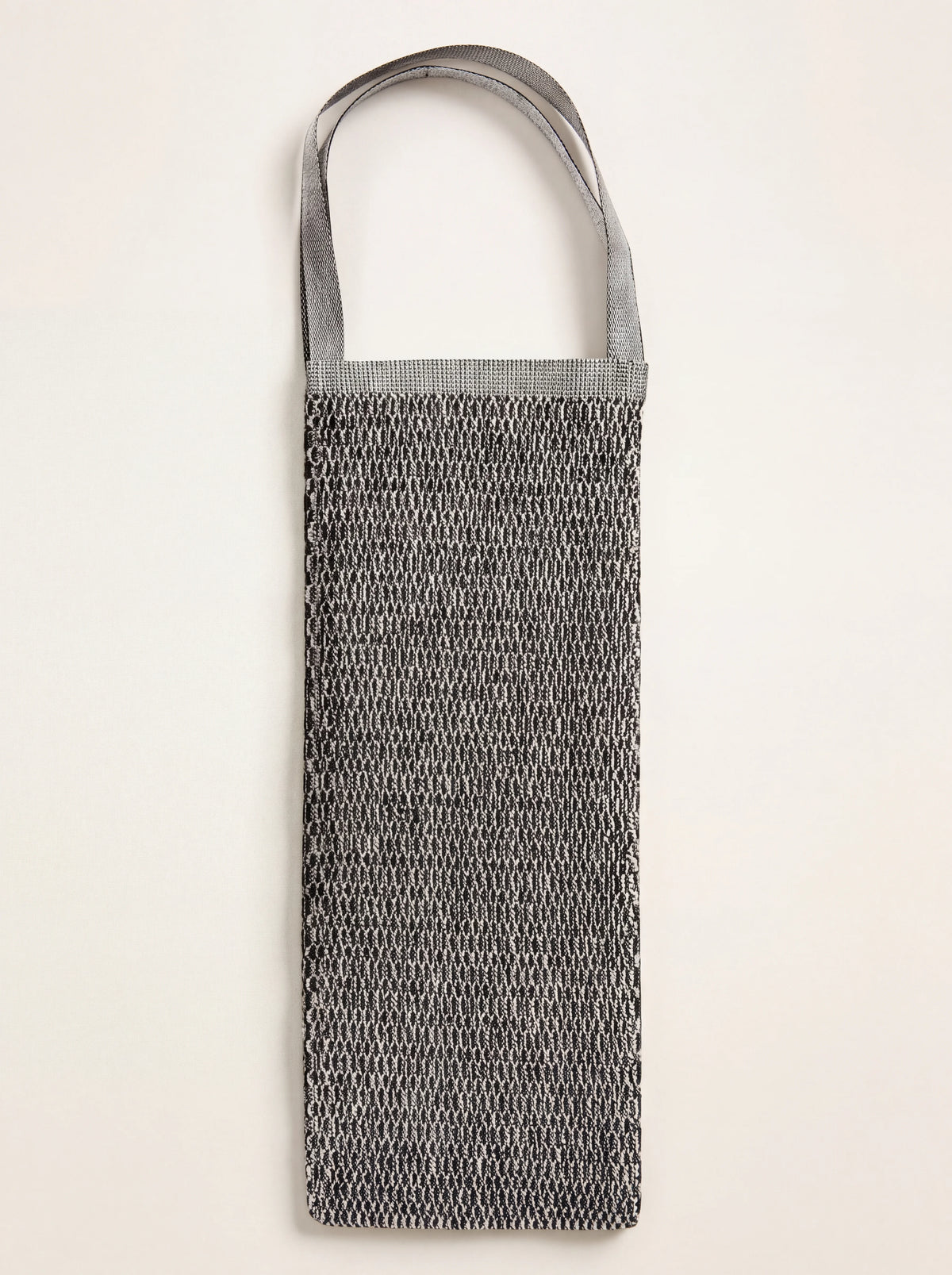 Linen back scrubber in a black and white two-tone weave with looped strap handles