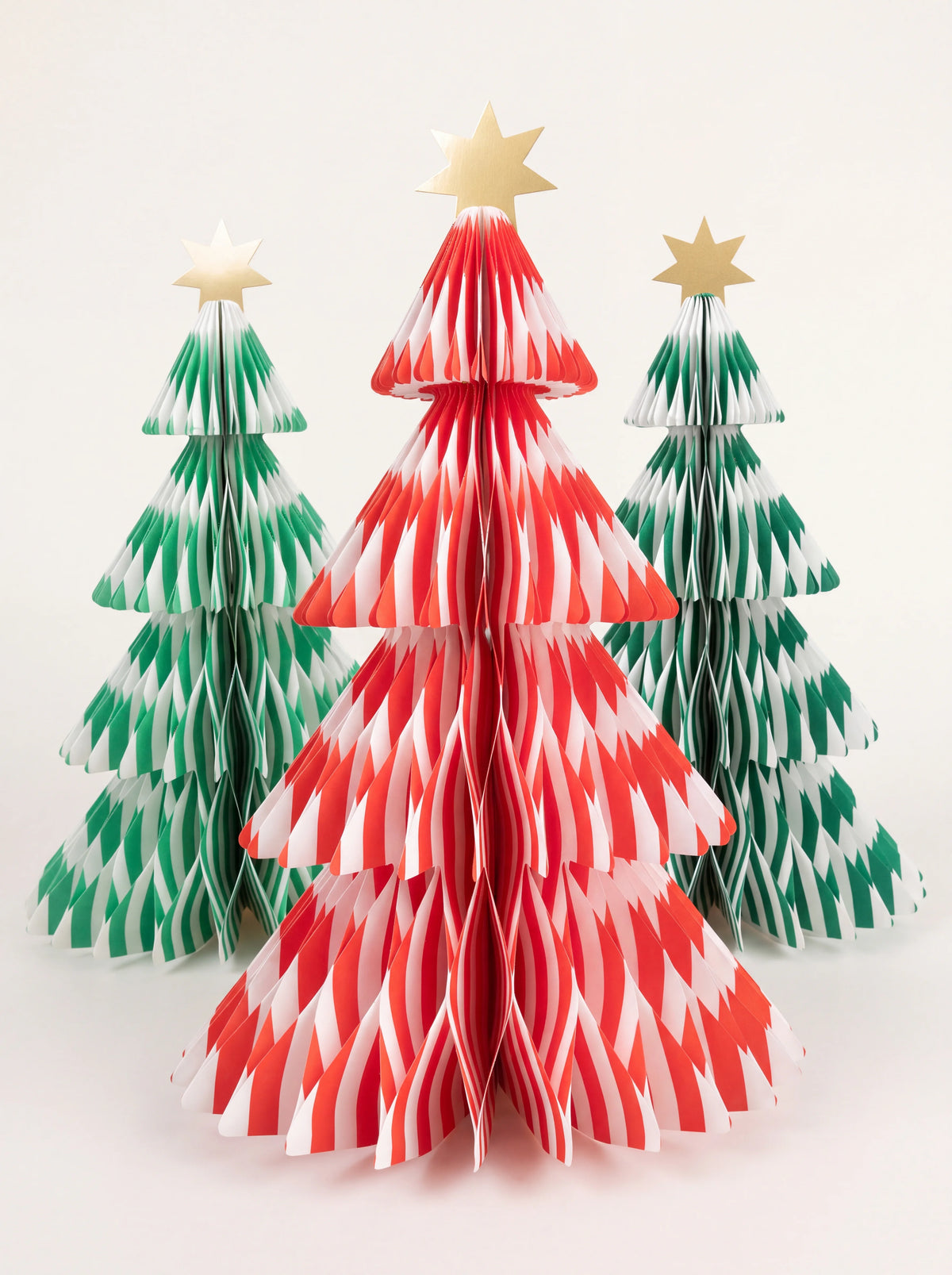 Striped honeycomb paper trees in red, mint and dark green, topped with gold foil stars