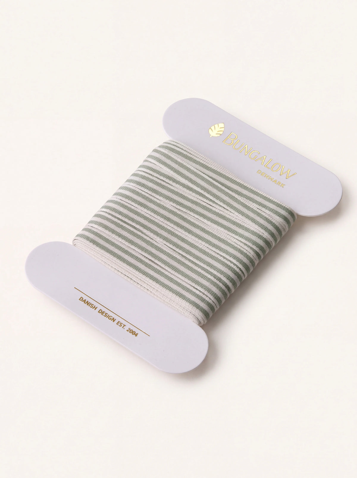 Ivy green and white striped woven ribbon wound onto a card spool