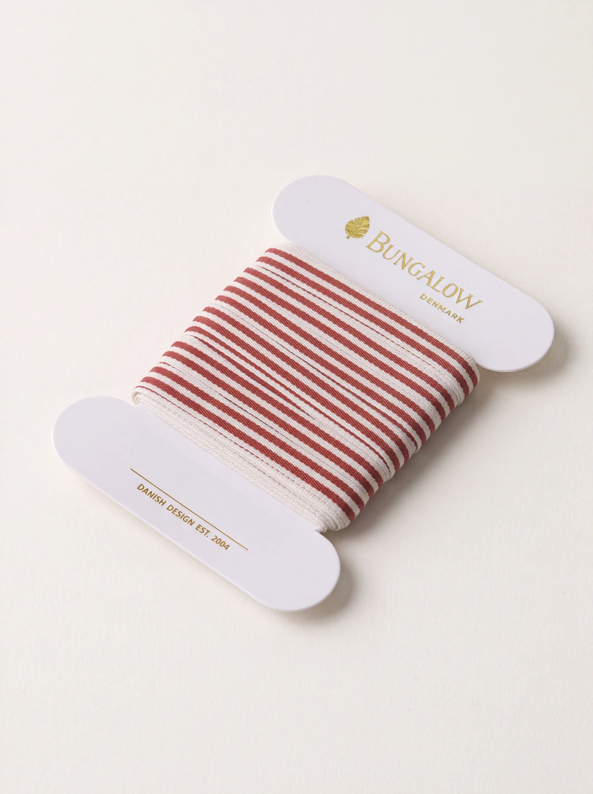 Scarlet and white striped woven polyester ribbon wound on a white card spool